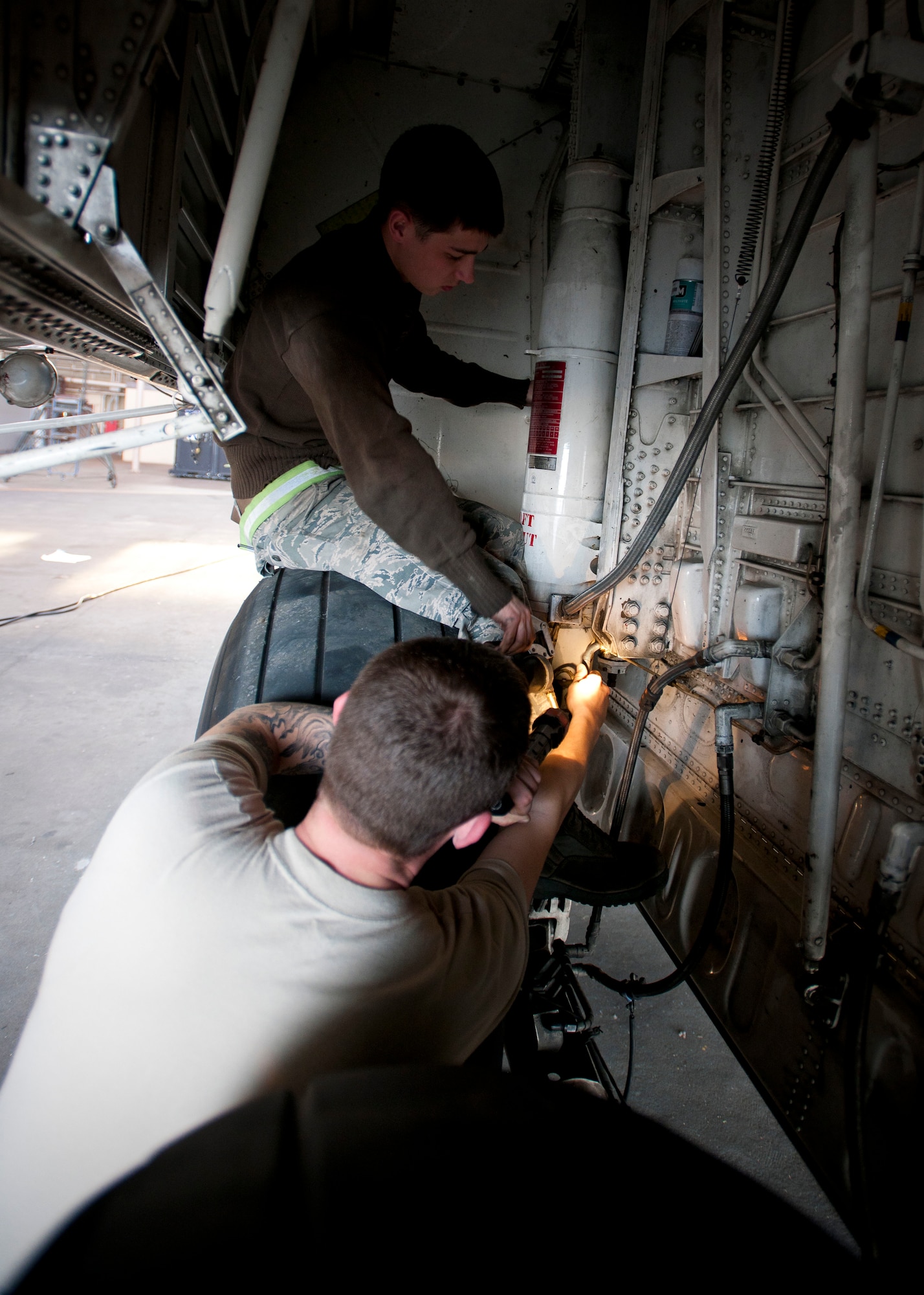 YOKOTA AIR BASE, Japan -- Airman 1st Class Andrew Meyer and Senior Airman Bruce Quillen, 374th Aircraft Maintenance Squadron crew chiefs check the landing gear on a C-130 Hercules for any indications of wear here April 2. In support of Operation Tomodachi, maintainers have worked extended hours to make sure all aircraft are ready for the relief effort. (U.S. Air Force photo/Staff Sgt. Chad C. Strohmeyer)