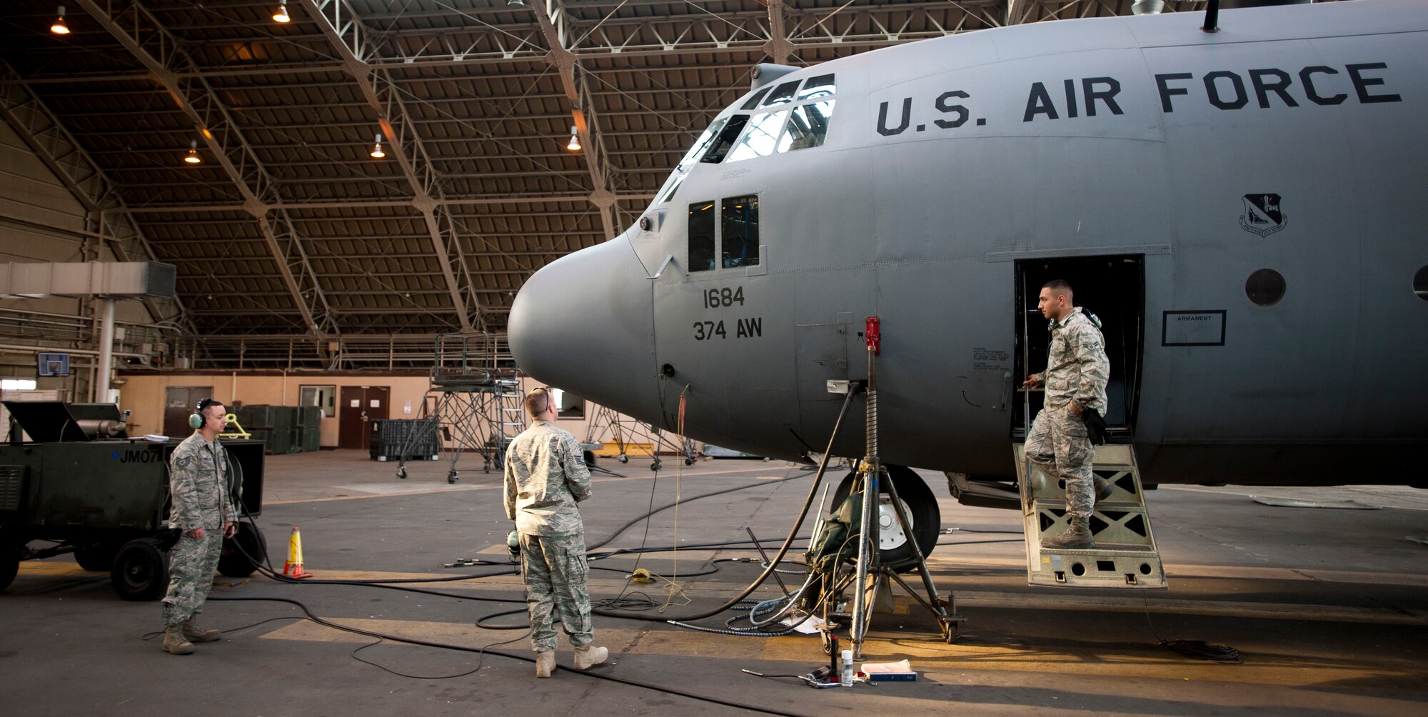 YOKOTA AIR BASE, Japan -- Airmen from the 374th Aircraft Maintenance Squadron prepare a C-130 Hercules to be lifted for maintenance here April 2. Hydraulics technicians were needed to prepare the jacks to lift the aircraft. (U.S. Air Force photo/Staff Sgt. Chad C. Strohmeyer)