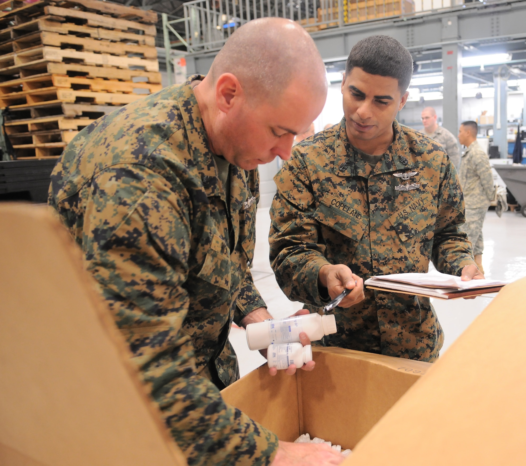 YOKOTA AIR BASE, Japan --  Navy Petty Officer 1st Class Stephen Michel , (left), Navy Medical Center, San Diego Calif., radiation health technician, and Navy Senior Chief Petty Officer Claude Copeland, (right), 1st Marine Air Wing, Okinawa, medical operations officer, check expiration dates for medications here April 4, 2011. The medications will be used in medical kits shipped to Sendai, aiding those affected by the earthquake and tsunami. (U.S. Air Force photo/Airman 1st Class Krystal M. Garrett) 