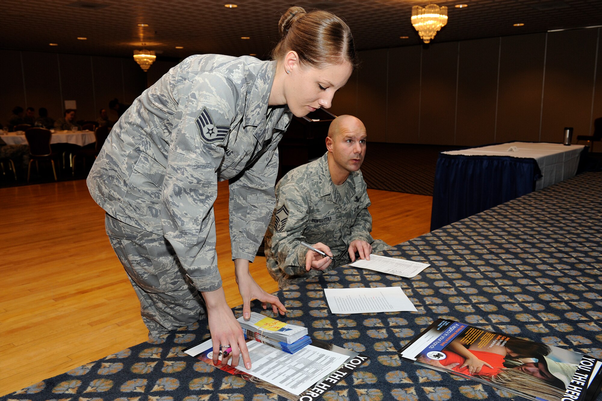 Staff Sgt. Jessica Thomas (front), Air Force Office of Special Investigations, collects her Air Force Assistance Fund sign-up slips and poster from Senior Master Sgt. John Bentivegna, 76th Space Control Squadron superintendent and a Peterson 2011 AFAF installation project officer. Unit reps received breakfast and training March 29 at The Club on how to effectively manage and distribute AFAF information to unit personnel. The campaign is underway now to May 6. (U.S. Air Force photo/Craig Denton)