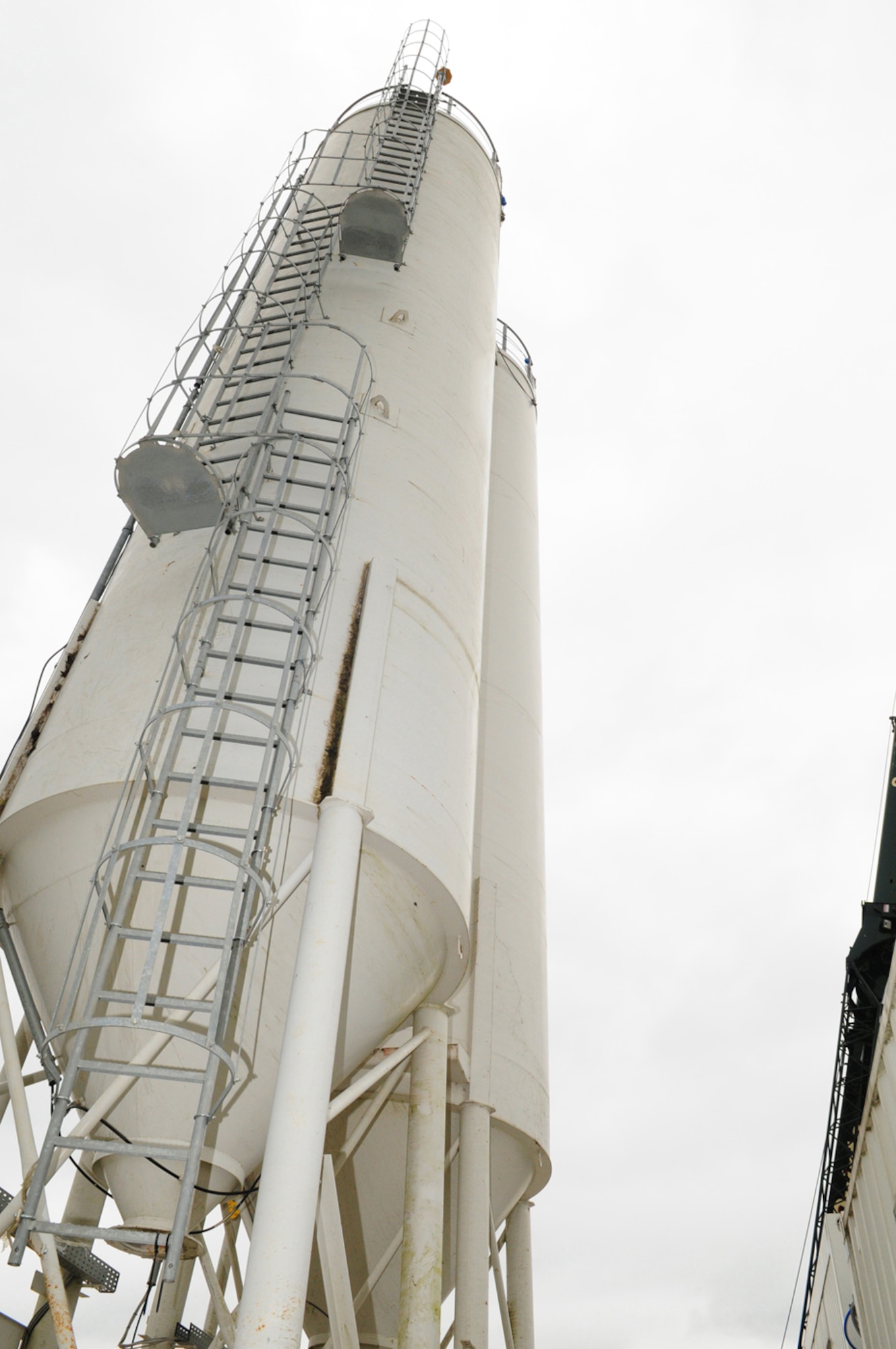 RAF MILDENHALL, England -- Two silos are part of the final pieces of the concrete batching plant which has just been built here March 30, 2011. The temporary plant has the ability to mix more than 2.6 tons of concrete at a time. By mixing concrete on base, the number of trucks necessary to complete airfield pavement works will be significantly reduced, thereby reducing the volume of traffic on local roads and lowering congestion at the main gate here. (U.S. Air Force photo/Karen Abeyasekere) 
