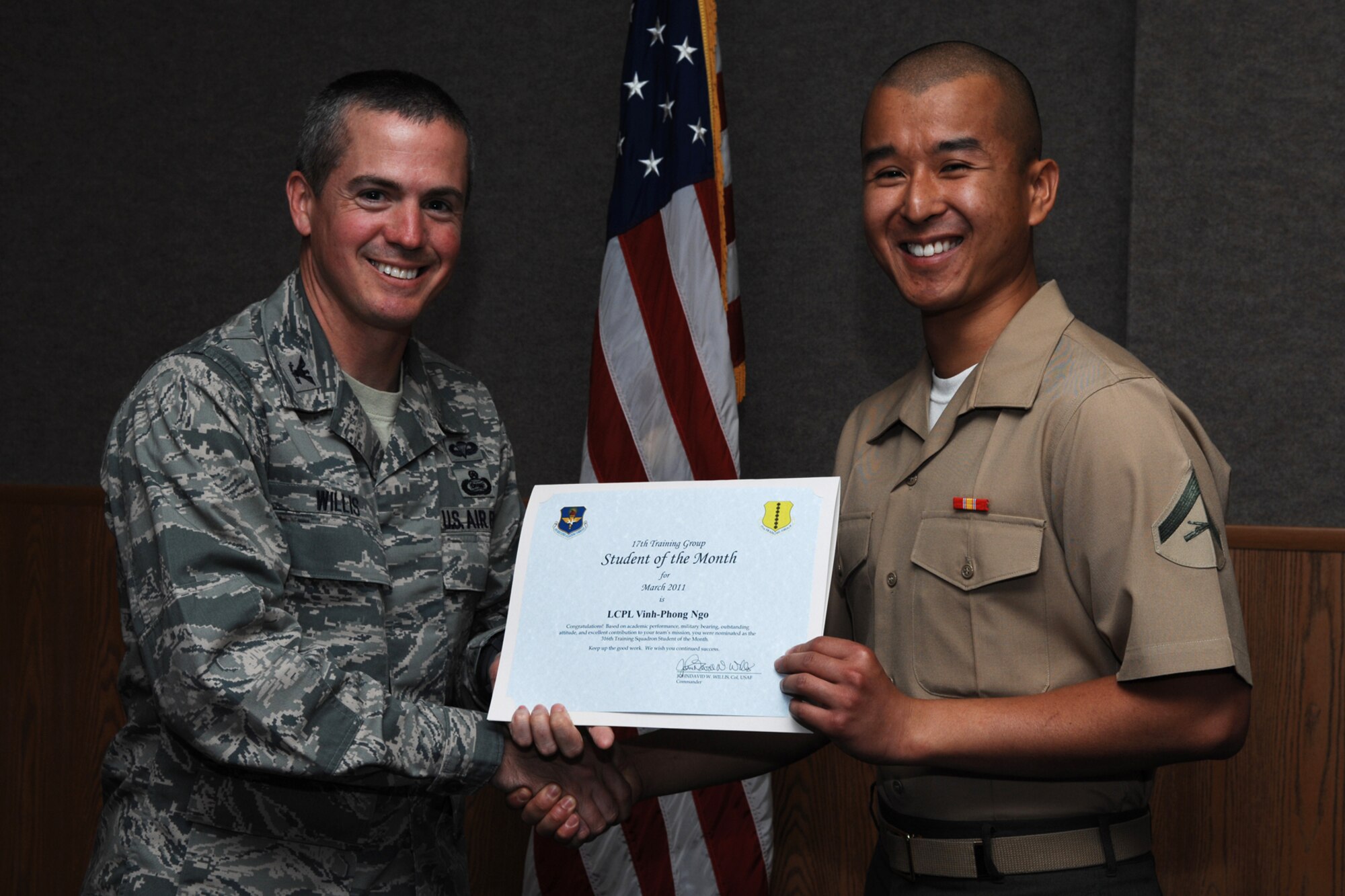 GOODFELLOW AIR FORCE BASE, Texas -- Marine Lance Cpl. Ving-Phong Ngo, 316th Training Squadron, receives Student of the Month certificate from Col. J.D. Willis, 17th Training Group commander, April 1, 2011. (U.S. Air Force photo/Staff Sgt. Laura R. McFarlane)