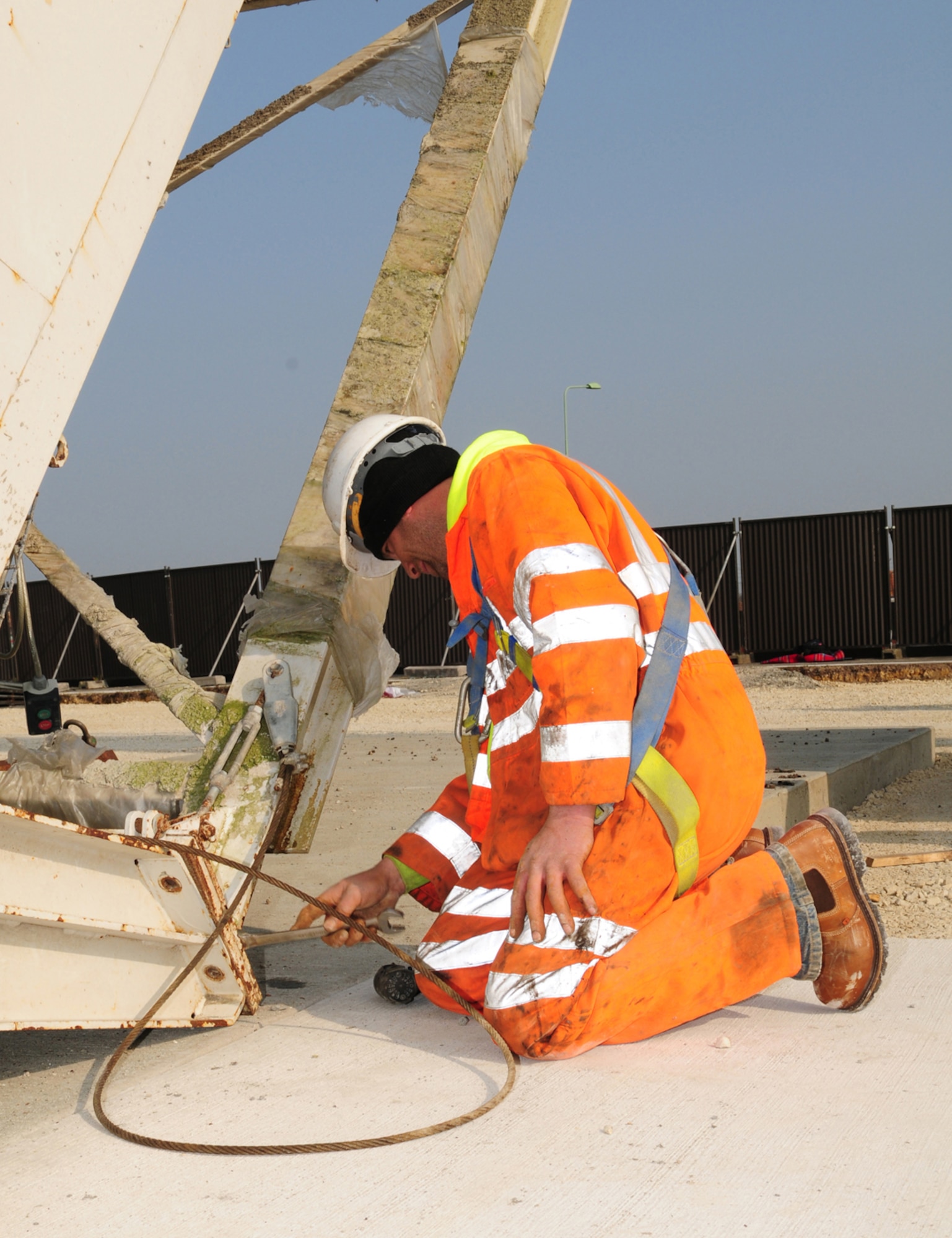 RAF MILDENHALL, England -- Simon Taylor, a contract worker, secures bolts to an A-frame mixer plant March 29, 2011, which is part of the temporary concrete batching plant here. The plant will enable contractors to mix concrete on site, rather than having to transport many truckloads of ready-mixed concrete from miles away. This will reduce the base's carbon footprint and save money. (U.S. Air Force photo/Karen Abeyasekere)