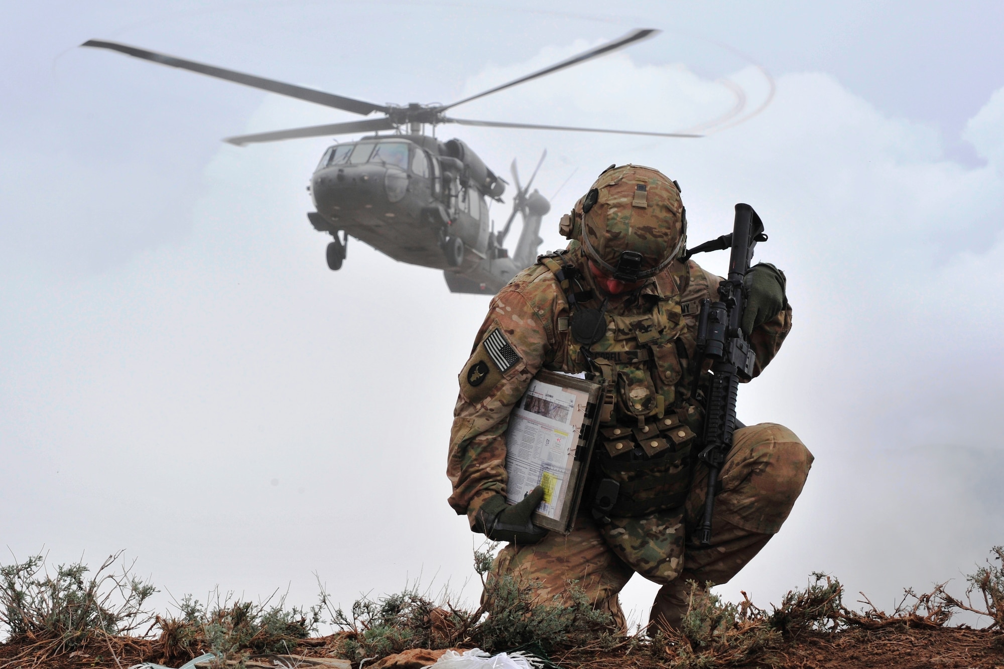 U.S. Army Col. Benjamin J. Corell, Task Force Red Bulls commander, takes cover as a UH-60 Blackhawk lands upon a mountaintop in Laghman province, Afghanistan, March 28, 2011, during Operation Bull Whip. Joint Terminal Attack Controllers were among the 2,200 coalition troops involved in the operation to clear the Galush Valley of insurgents. (U.S. Air Force photo by Capt. Erick Saks)