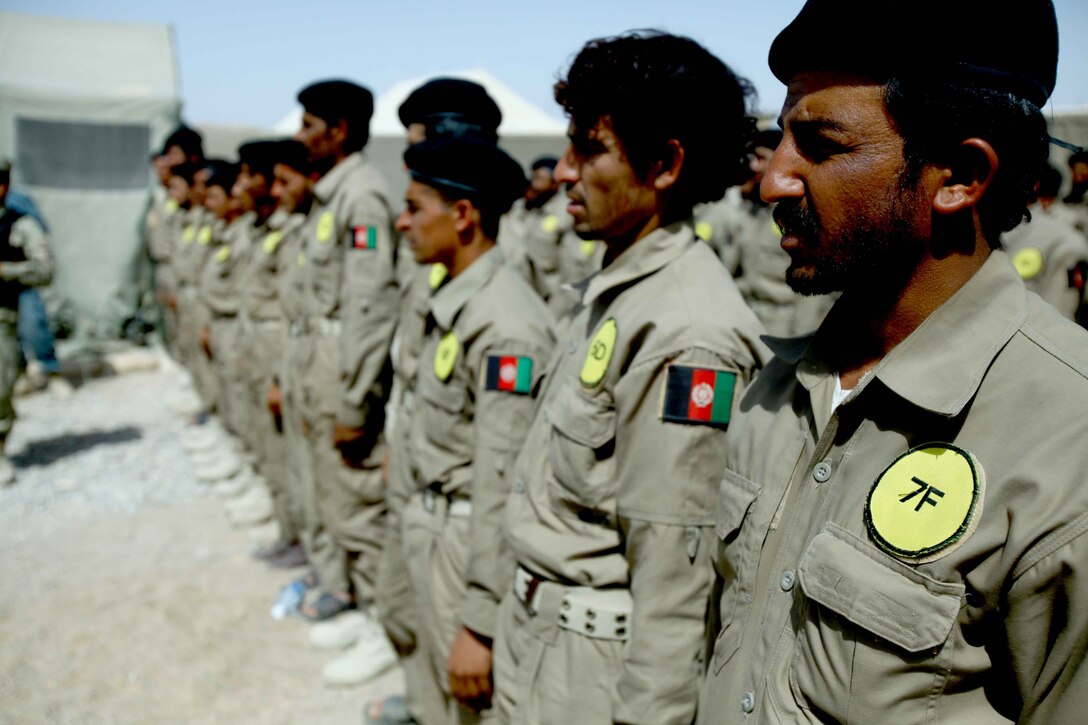 Graduates stand at attention during the Afghan Local Police (ALP) graduation ceremony at Forward Operating Base Marjah, Afghanistan, April 4, 2011. After 3 weeks of training with the U.S. Marine Corps Police Mentor Team, 3rd Battalion, 9th Marine Regiment, Regimental Combat Team 1, the Interim Security Critical Infrastructure members graduated to the newly constructed ALP. (U.S. Marine Corps photo by Lance Cpl. Christopher M. Carroll/Released)