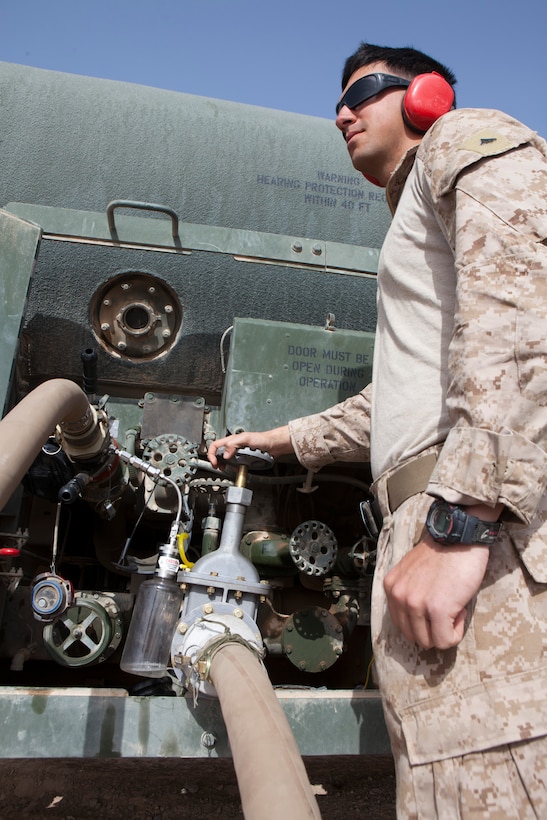 Lance Cpl. Wade Skaff, a motor transport specailist with Marine Wing Support Squadron 272, extracts fuel from a MK-970 fuel tank for inspection, Lance Cpl. Adolfo J. CarreraCruz, a bulk fuel specialist with Marine Wing Support Squadron 272, measures fuel levels of a fuel truck at a new forward arming and refueling point at Combat Outpost Ouellette in Afghanistan's Helmand province, April 5.The forward arming and refueling point was recently constructed at Combat Outpost Ouellette to enable 2nd Marine Aircraft Wing (Forward) to better support Marines and other coalition troops operating near Sangin, Afghanistan.