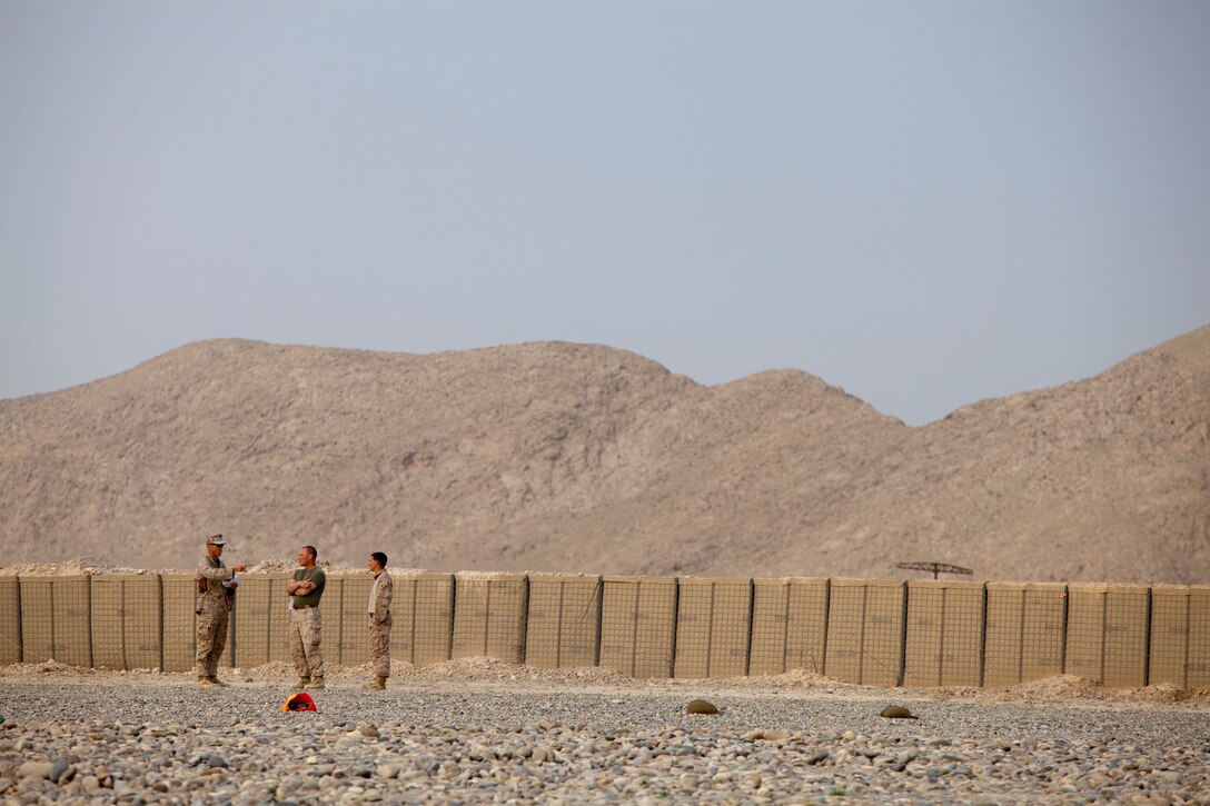 From left to right, Chief Warrant Officer 3 Danny R. Rominger, Staff Sgt. Rockey Crump and Sgt. Andrew Ceniccola, all with 2nd Marine Aircraft Wing (Forward), discuss overall production in re-supplying, re-fueling and arming aircrafts at a new forward arming and refueling point at Combat Outpost Ouellette in Afghanistan's Helmand province, April 5.The forward arming and refueling point was recently constructed at Combat Outpost Ouellette to enable 2nd Marine Aircraft Wing (Forward) to better support Marines and other coalition troops operating near Sangin, Afghanistan.
