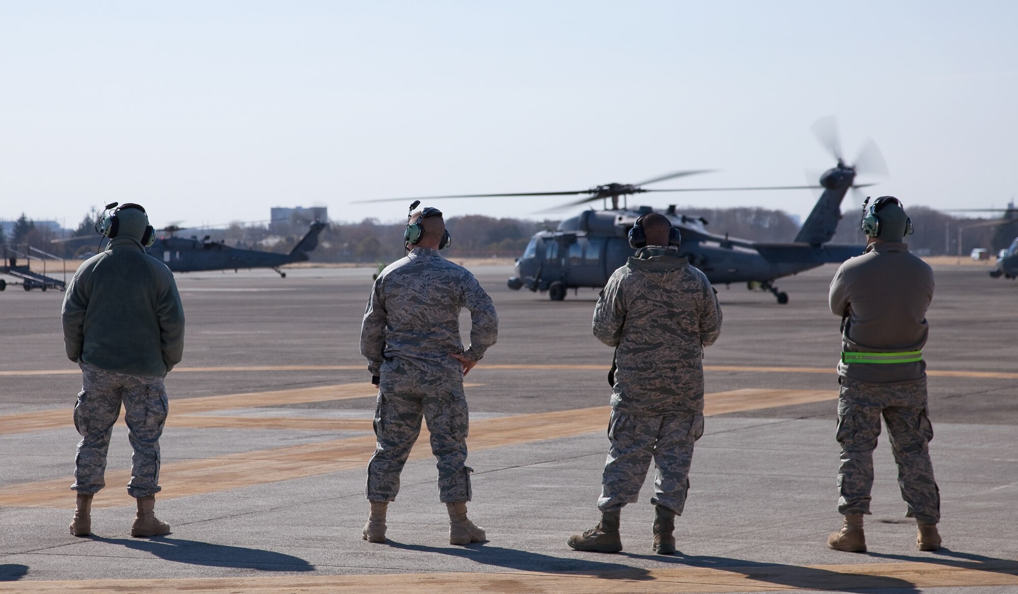 YOKOTA AIR BASE, Japan -- Maintainers from the 718th Aircraft Maintenance Squadron watch as HH-60G Pave Hawk helicopters depart here April 4, 2011. The bulk of U.S. forces are repositioning to their respective forward deployed locations within Japan and remain prepared to provide rapid response to requests for assistance should the need arise. (U.S. Air Force photo/Osakabe Yasuo)