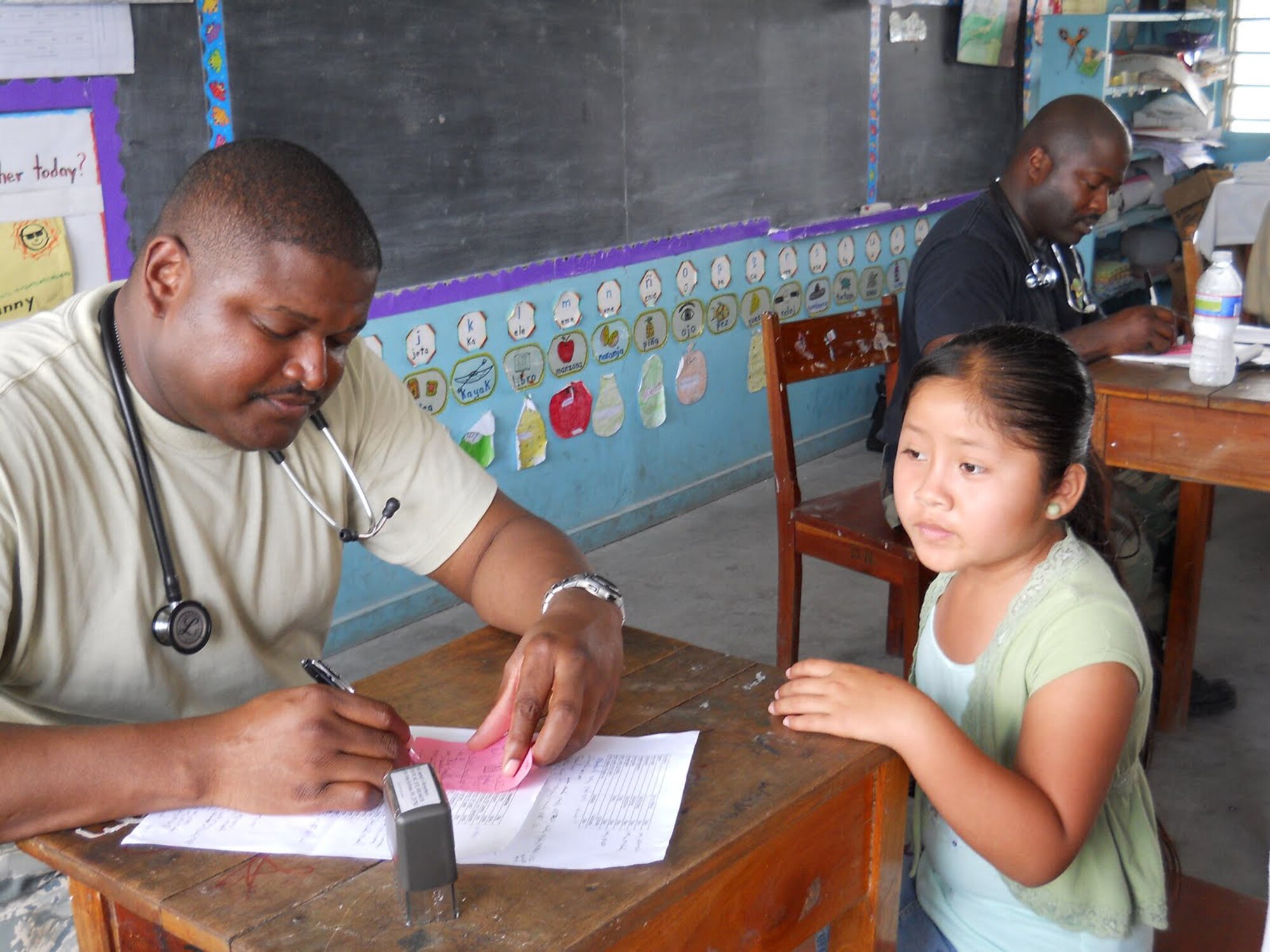 A medical specialist from the 459th Aerospace Medicine Squadron, takes information from a child in a village in Belize on April 1. The medical Airman joined other Reserve servicemembers from the 459th Air Refueling Wing at Joint Base Andrews, Md., to particpate in a Medical Readiness Training Exercise from March 26 to April 9. The MEDRETE is designed to bring humanitarian assistance and free medical care to its host country citizens. Over 42 medical professionals from units across the U.S. Air Force participated this year in the joint exercise. (Submitted U.S. Air Force photo)