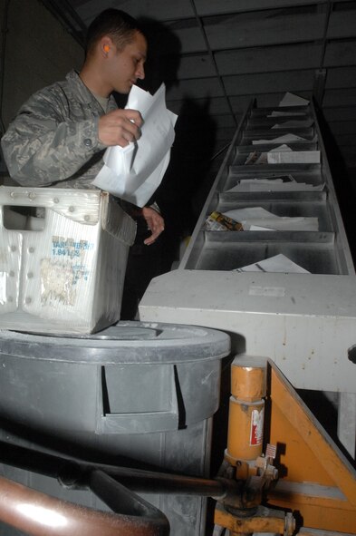 Airman 1st Class Kevin Spiegel, 2nd Communications Squadron, feeds documents into the base disintegrater April 5 at Barksdale Air Force Base, La. The base disintegrater shreds classified and unclassified documents four times a week. (U.S. Air Force photo/Senior Airman Allison M. Boehm)(RELEASED) 