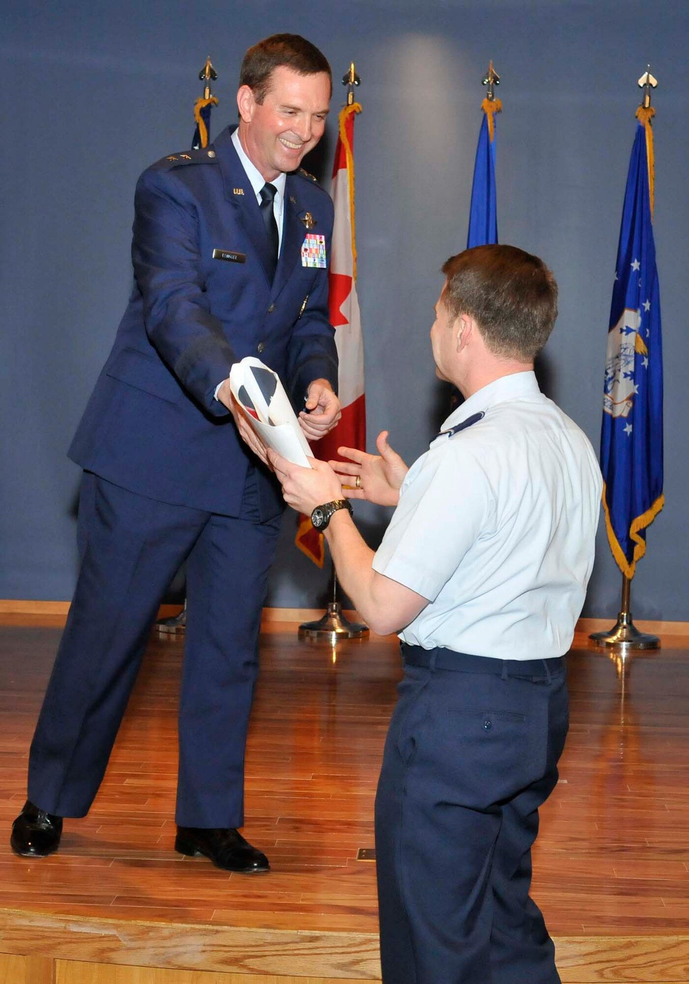 Maj. Gen. Joseph Lengyel jokingly hands off some one-star memorabilia to his brother Brig. Gen. Greg Lengyel during his promotion ceremony at Tyndall Air Force Base, Fla., April 1. General Lengyel is the 1st Air Force (Air Forces Northern) vice commander. (U.S. Air Force photo by Lisa Norman)
