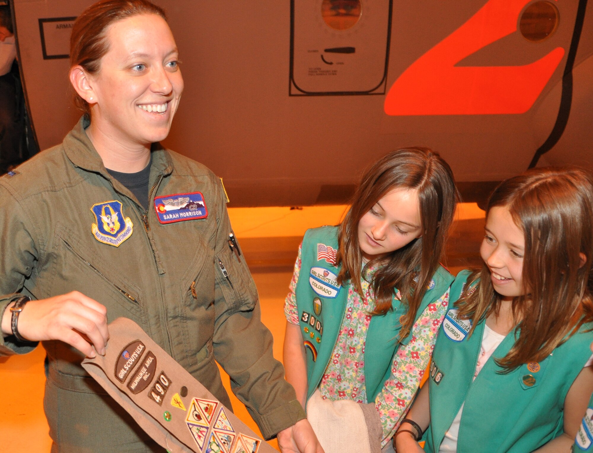 First Lt. Sarah Morrison, a Reserve pilot with the 731st Airlift Squadron, shows Girl Scouts Megan Walker, left, and Sabrina Tirrill her sash from when she was a Brownie.  Six Girl Scouts from troop 3008 visited April 3 to tour a C-130H aircraft and the 302nd Airlift Squadron at Peterson AFB. (U.S. Air Force photo/Tech. Sgt. Daniel Butterfield)