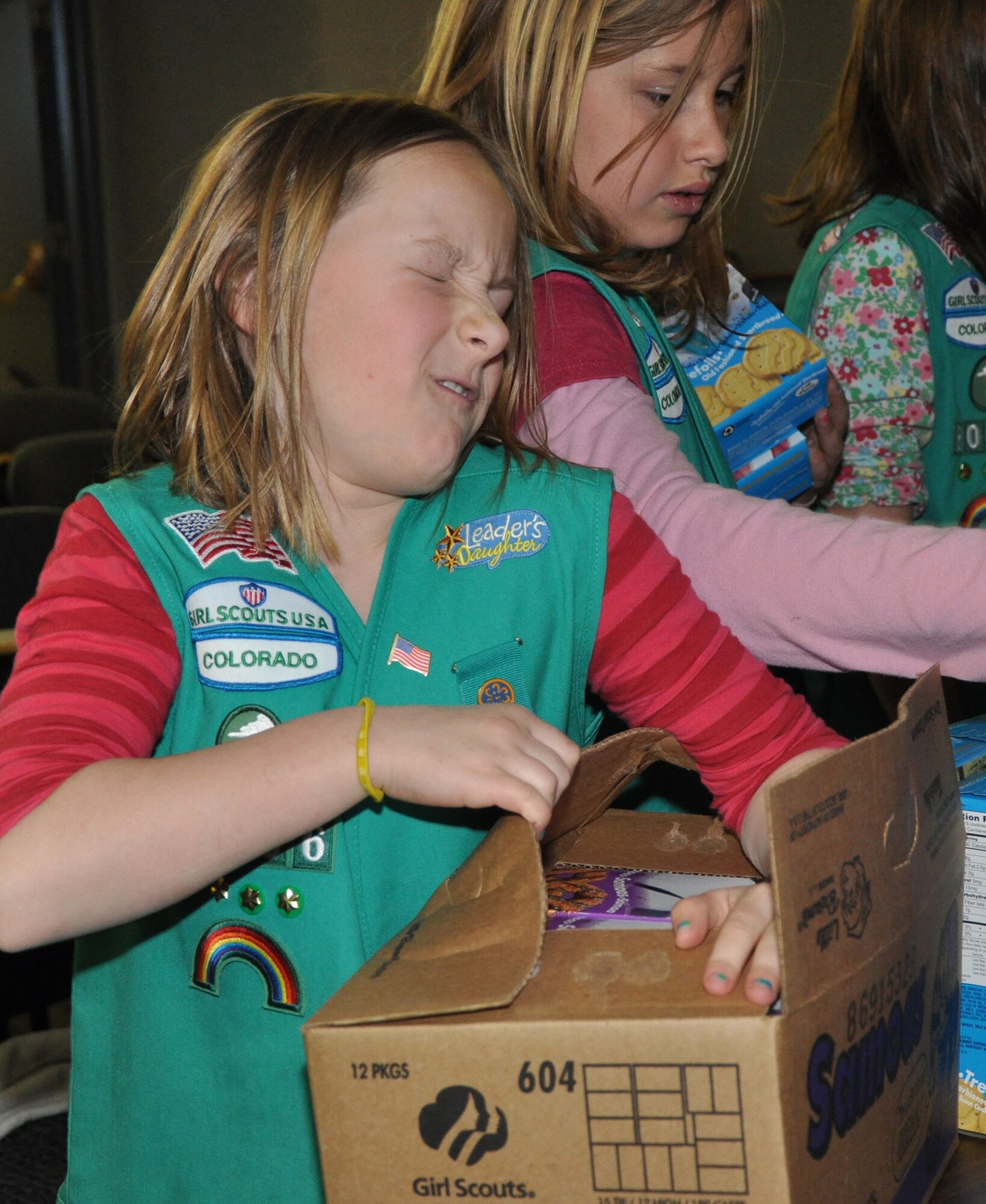 Anna Hemphill opens a case of Girl Scout cookies while Katelynn Griffin organizes the boxes. Six Girl Scouts from troop 3006 visited April 3 to meet with Reservists from the 302nd Airlift Wing, Peterson AFB and to tour a C-130H aircraft. (U.S. Air Force photo/Tech. Sgt. Daniel Butterfield)