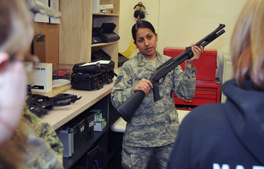 OFFUTT AIR FORCE BASE, Neb. -- Staff Sgt. Tracy Howard, NCO in charge of the 55th Security Forces Squadron armory, shows eight students from St. Mary?s High School (Kansas) an M-870 shotgun and explains how security forces Airmen use it inside the armory here March 24. The students visited the armory as part of a base tour. U.S. Air Force Photo by Jeff W. Gates