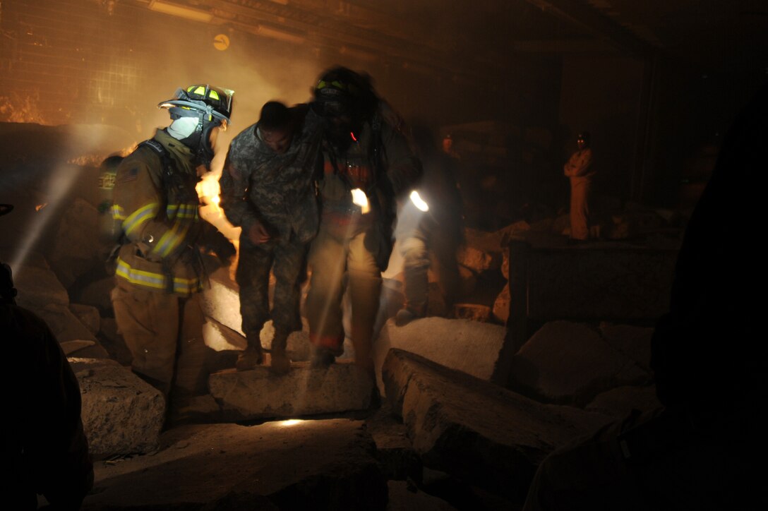 Fire fighters from the 11th Civil Engineer Squadron rescue Sgt 1st Class Francisco Campos, Pentagon Force Protection Agency chemical, biological, radiological, nuclear or high-yield explosive specialist, from the rubble after a mock mass causality disaster in the commissary at the Center for Center for National Response in Gallagher, W. Va, March 31, during exercise Black Flag. Black Flag cadre along with local civilians acted in injured victims to give the fire department more of a realistic feel. (U.S. Air Force photo by Senior Airman Melissa V. Brownstein)