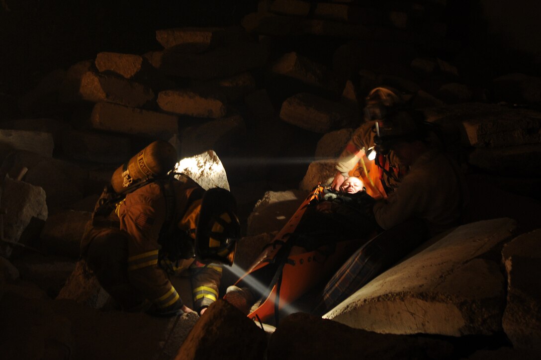 11th Civil Engineer Squadron fire fighters rescue Staff Sgt. Jesse Ford, 779th Aerospace medicine squadron bioenvironmental engineer craftsman, from the rubble in a mock mass causality disaster in the commissary at the Center for Center for National Response in Gallagher, W. Va, March 31, during exercise Black Flag. Black Flag is a full-scale exercise based potential risks to the national capital region and deployed environments. (U.S. Air Force photo by Senior Airman Melissa V. Brownstein)
