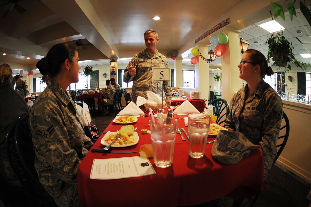 Chief Master Sgt. Charles Anderson, 633rd Air Base Wing command chief celebrates with Airman 1stClass Amanda Williams, 1st Maintenance Group knowledge operations manager and Airman 1st Class Jessica Scott, 1st Maintenance Group knowledge operations manager, during a birthday meal held at Langley Air Force, March 31, 2011. The dining facility honors dorm resident birthdays each month with a special meal in their honor. (U.S. Air Force photo by Senior Airman Brian Ybarbo/Released)   