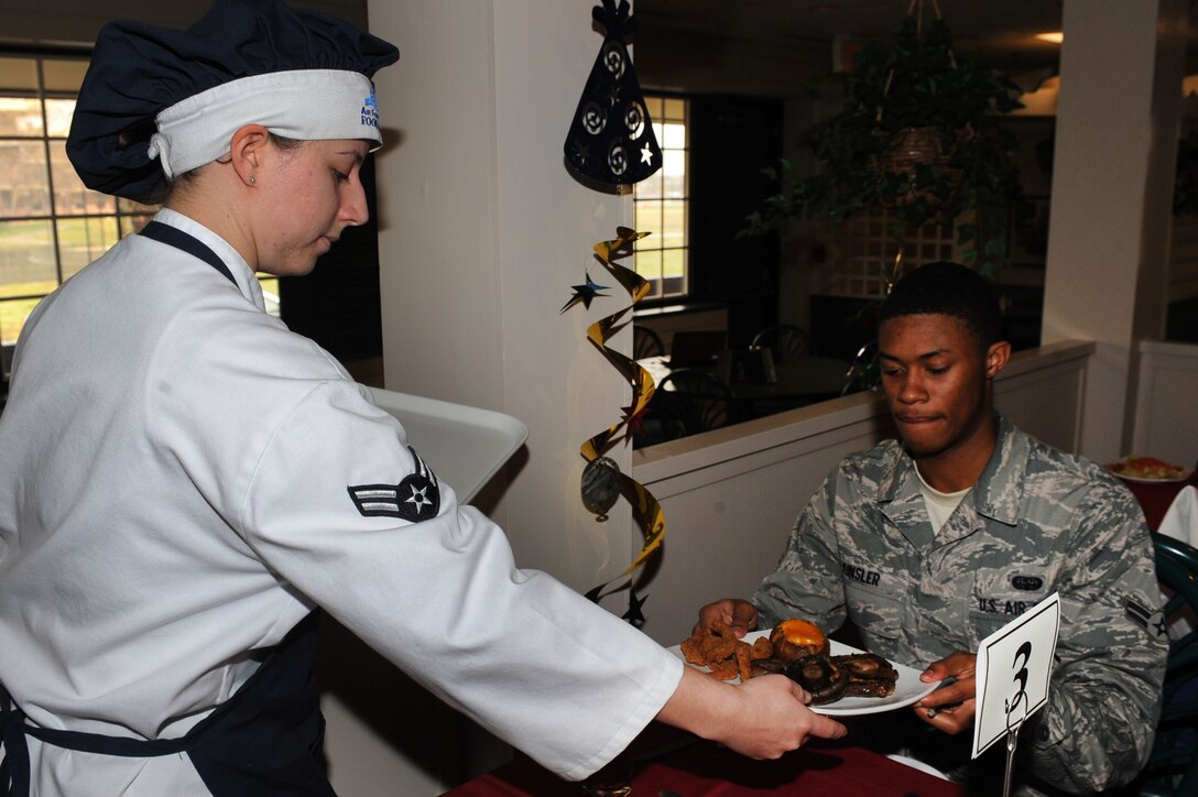Airman 1st Class Stephanie Payne, 633rd Force Support Squadron food services specialist, delivers a meal to Airman 1st Class Corey Kinsler, Air Combat Command field technician, during a birthday meal held at Langley Air Force Base, Va., March 31, 2011. The dining facility honors dorm resident birthdays each month with a special meal in their honor. (U.S. Air Force photo by Senior Airman Brian Ybarbo/Released)   