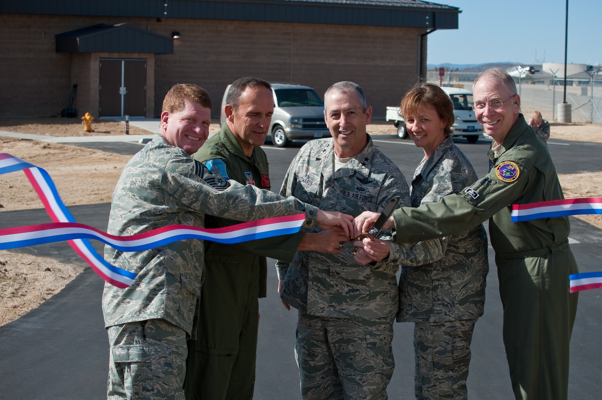 (From left to right) Chief Master Sgt. John Criswell, 140th Wing Command Chief, Brig. Gen. Trulan Eyre, 140th Wing Commander, Maj. Gen. H. Michael Edwards, Colorado Adjutant General, Chief Master Sgt. Annadele Kenderes, State Command Chief Master Sgt. and Brig. Gen. William Hudson, Colorado Air National Guard Commander cut the ribbon and officially open the new 140th Alert Crew building 911 April 2. (U.S. Air Force photo/Master Sgt. John Nimmo, Sr.) (RELEASED)