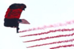 A Black Dagger makes his entrance while streaming smoke. The Black Daggers are the official U.S. Army Special Operations Command Parachute Demonstration team. (Photo courtesy/U.S. Army)