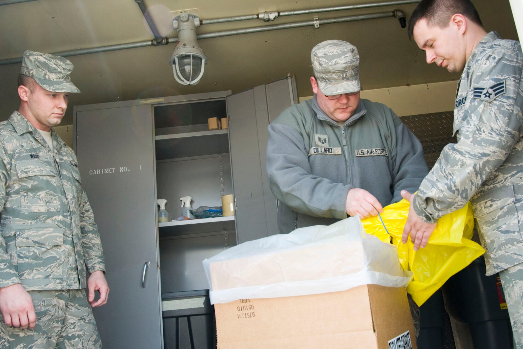 Staff Sgt. Patrick Ware, Tech Sgt. Ben Dillard, and Senior Airman Terry Whittington demonstrate procedures for handling regualted trash inside the designated regulated trash shed at the 167th Airlift Wing on April 1, 2011. The unit recently certified 18 Airmen to act as inspectors for the Domestic Military Customs Inspections Program.  (U.S. Air Force photo by MSgt Emily Beightol-Deyerle) 