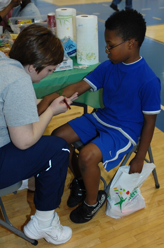 Tech Sgt. Julie Nix, 633d Force Support Squadron fitness craftsman, paints a dinosaur on eight year old Leon Fitzgerald III, son of Staff Sgt. Godwin, 633d Logistics Readiness Squadron vehicle operator, during Family Fun Day at the Shellbank Fitness Center at Langley Air Force Base, Va., April 2, 2011. Families enjoyed workout stations, balloon sculpting, and many other events during Family Fun Day to kick off Month of the Military Child. (U.S. Air Force photo by Airman 1st Class Teresa Zimmerman/Released)