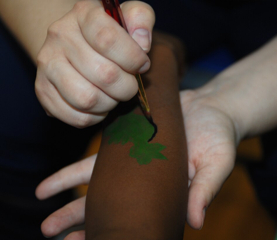 Tech Sgt. Julie Nix, 633d Force Support Squadron fitness craftsman, paints a dinosaur on eight year old Leon Fitzgerald III, son of Staff Sgt. Godwin, 633d Logistics Readiness Squadron vehicle operator, during Family Fun Day at the Shellbank Fitness Center at Langley Air Force Base, Va., April 2, 2011. Families enjoyed workout stations, balloon sculpting, and many other events during Family Fun Day to kick off Month of the Military Child. (U.S. Air Force photo by Airman 1st Class Teresa Zimmerman/Released)
