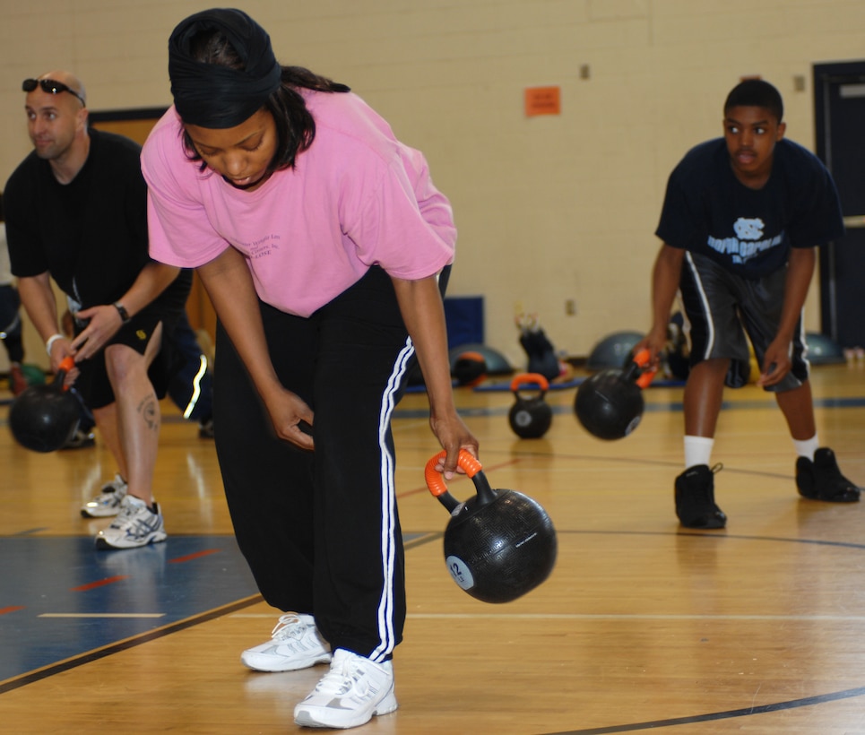 Army Staff Sgt. David Scott, helicopter mechanic with the Army Aviations School, Angela Pope, Fleet Support Command administrative assistant and her son, eleven year old Jalen Thompson workout during Family Fun Day at the Shellbank Fitness Center at Langley Air Force Base, Va., April 2, 2011. Families enjoyed workout stations, balloon sculpting, and many other events during Family Fun Day to kick off Month of the Military Child. (U.S. Air Force photo by Airman 1st Class Teresa Zimmerman/Released)