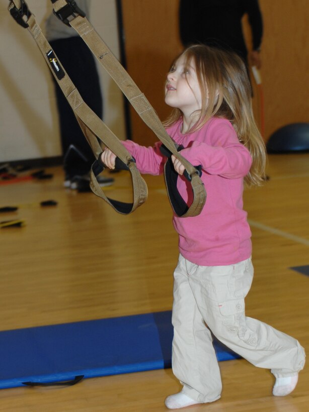 Taylin Skees, three year old, daughter of Staff Sgt. Holly Guidry, 633d Force Support Squadron, plays with TRX stretch bands during Family Fun Day at the Shellbank Fitness Center at Langley Air Force Base, Va., April 2, 2011. Families enjoyed workout stations, balloon sculpting, and many other events during Family Fun Day to start off Month of the Military Child. (U.S. Air Force photo by Airman 1st Class Teresa Zimmerman/Released)