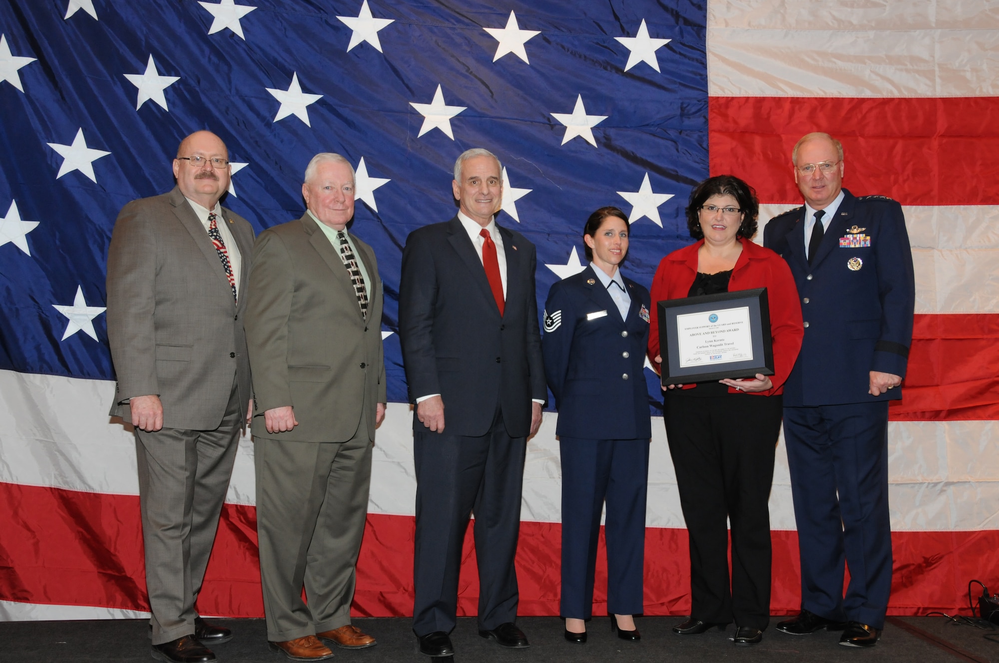 Lynn Kerntz (holding award) of Carlson Wagonlit Travel accepts the "Above and Beyond Award" during the Minnesota Employer Support for the Guard and Reserve (ESGR) Banquet held in Oakdale, Minn.  Mark Dayton (third from left), Governor of Minnesota and Gen. Craig McKinley, Chief, National Guard Bureau were on hand to present the awards.  (U.S. Air Force photo by Master Sgt. Ralph J. Kapustka)