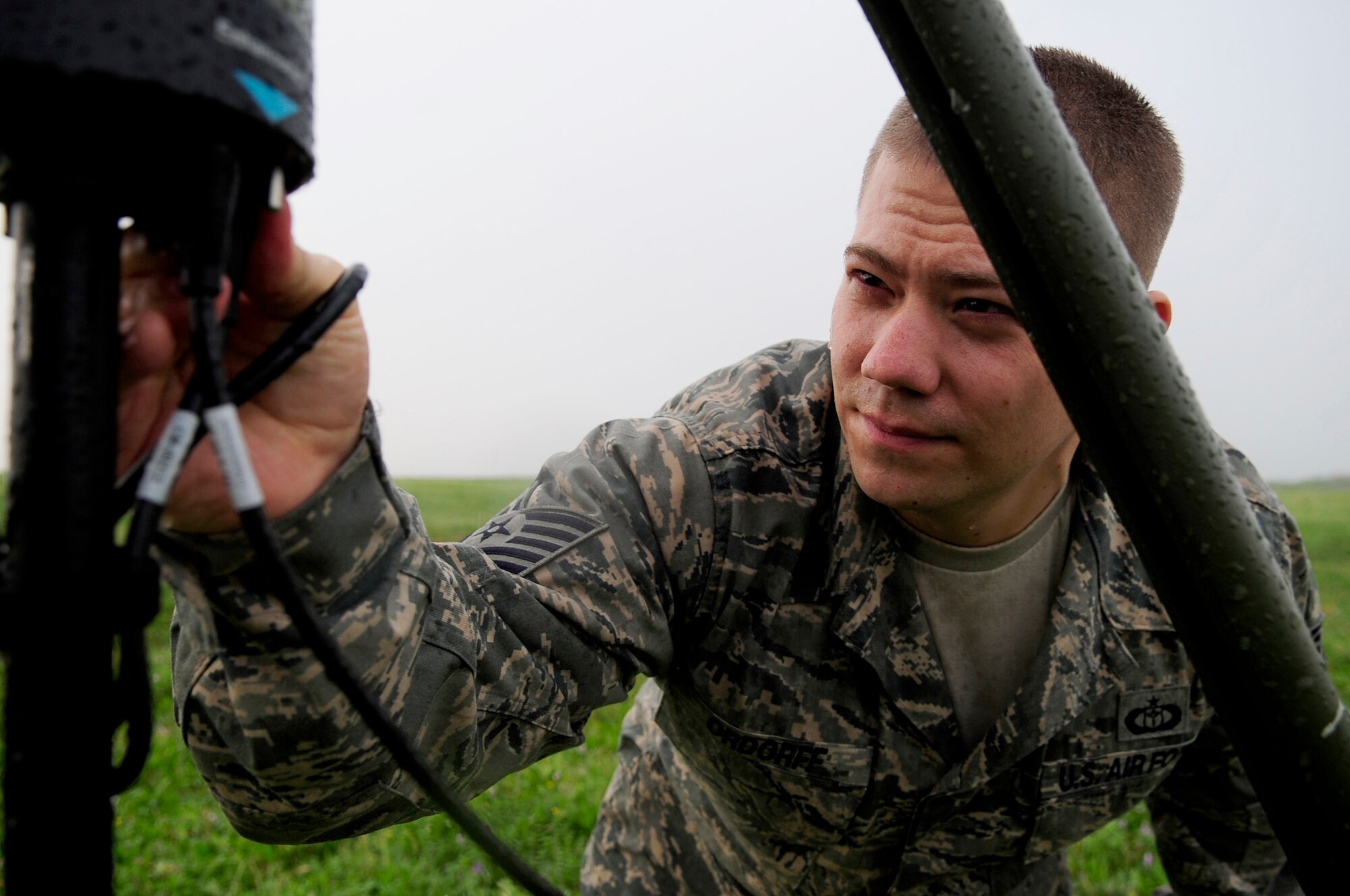 313th AIR EXPEDITIONARY WING (April 3, 2011) - Tech. Sgt. Matthew Ordorff, 100th Air Refueling Wing weather technician, deployed from Royal Air Force Mildenhall, England, checks a AN/TMQ-53 Tactical Meteorology Sensor Suite wire connection in the rain, in support of Operation Unified Protector. Unified Protector is a NATO-led operation in Libya to protect civilians and civilian-populated areas under threat of attack. (U.S. Air Force photo/Senior Airman Ethan Morgan) 