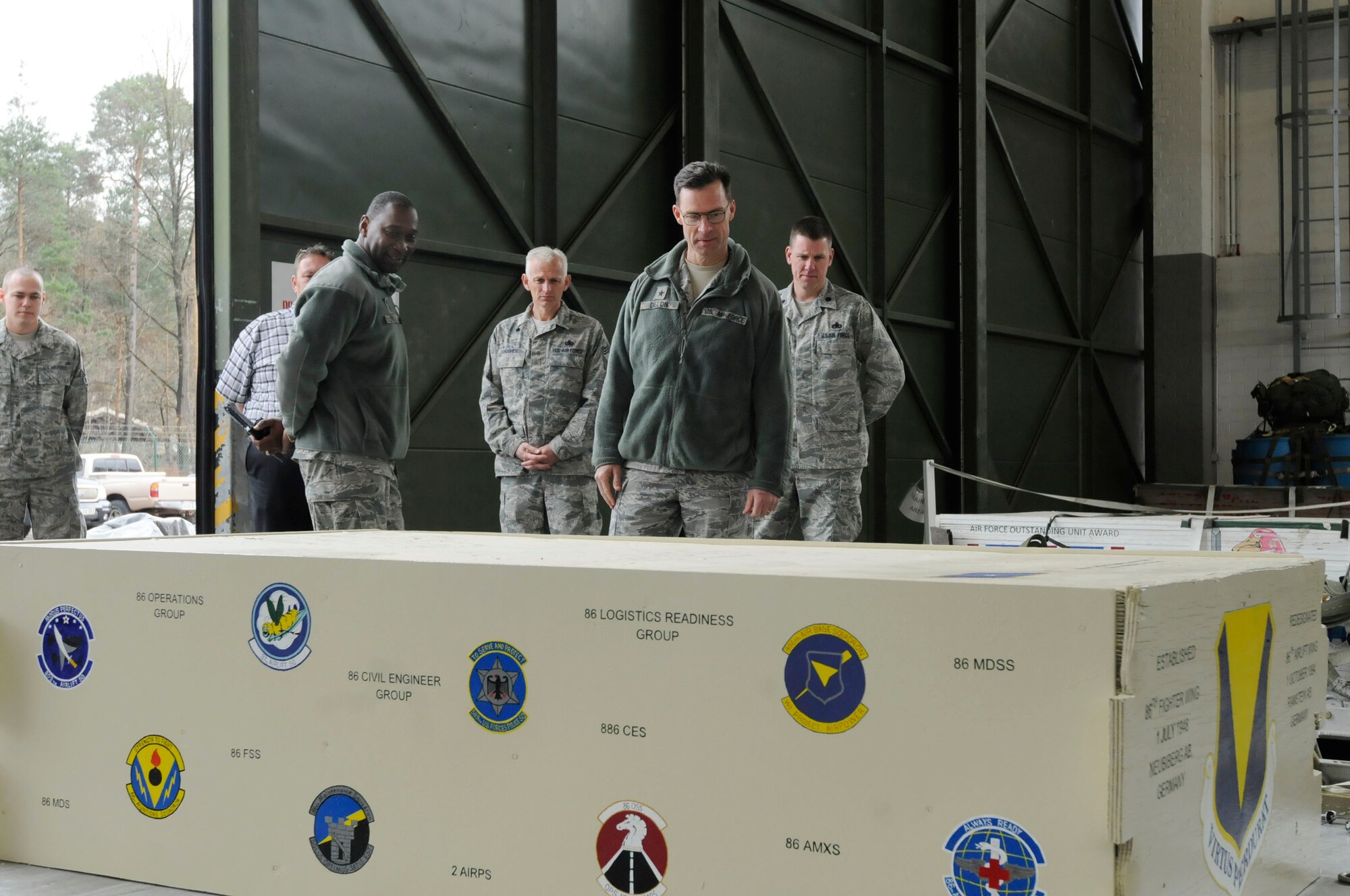 U.S. Air Force Brig. Gen. Mark Dillon, 86th Airlift Wing commander, and Chief Master Sgt. Vernon Butler, 86th AW command chief, observes a heavy training platform designed by Senior Airman Sarah Hathaway, 86th Logistics Readiness Squadron, Ramstein Air Base, Germany, April 4, 2011. The platform will be used to assist in training the 37th Airlift Squadron with heavy equipment airdrops. (U.S. Air Force photo by Airman Kendra Alba)