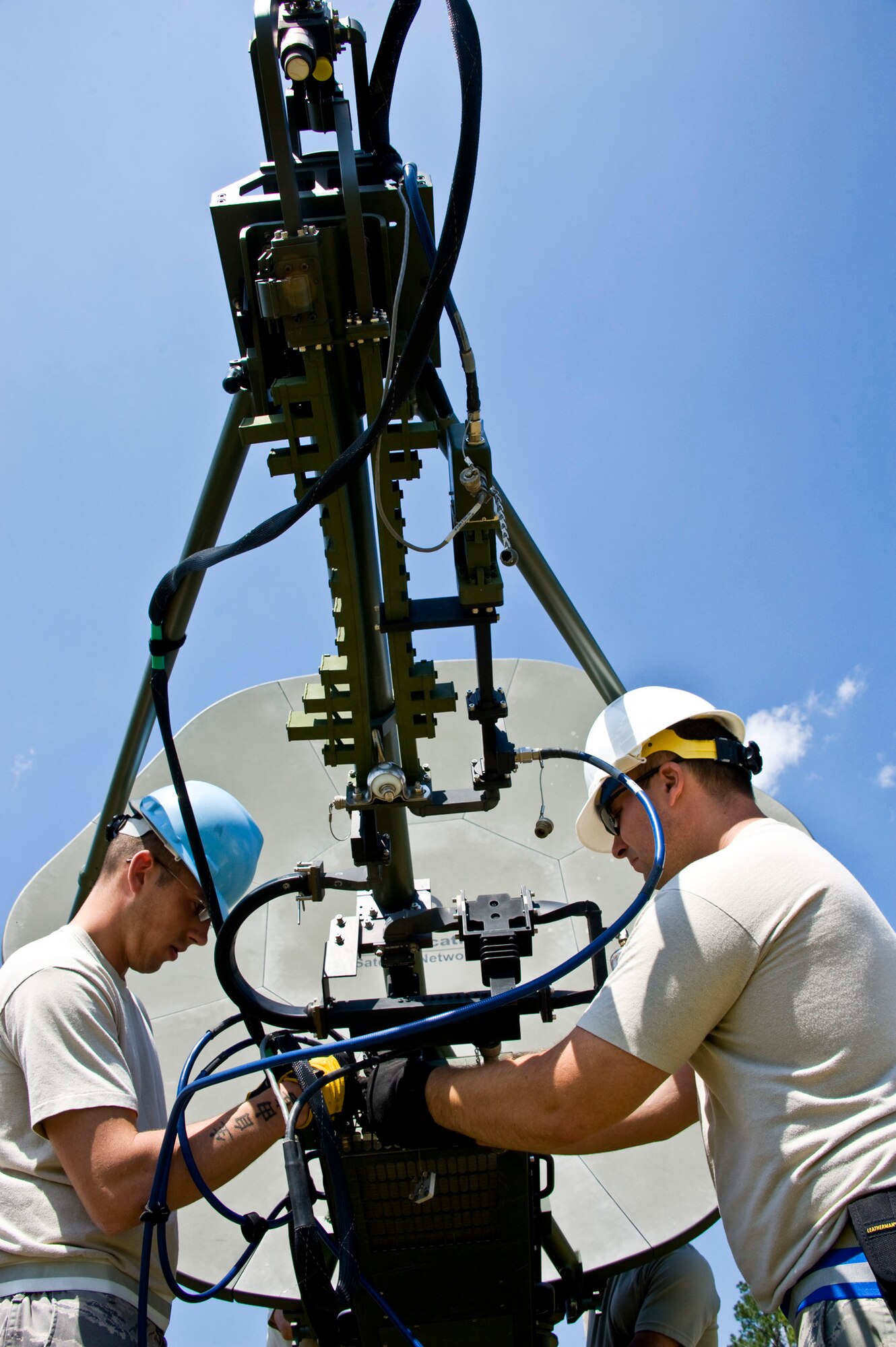 Senior Airman Ryan Adkins and Senior Airman Kristian Ray, 728th Air Control Squadron, set up the satellite communication terminal at Duke Field April 1 prior to a 10-day exercise. (U.S. Air Force photo/Tech. Sgt. Samuel King Jr.)