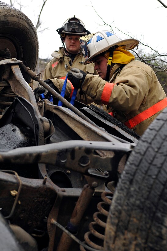 Staff Sgt. Daniel Fazio, 11 Civil Engineer Squadron (CES) fire fighter, stabilizes a rolled over vehicle with the guidance of Lieutenant Adam Burak, 11 CES fire fighter, during an auto extrication exercise at the Center for National Response in Gallagher, W. Va, March 30. Members of the fire department participate in Black Flag which gives them the opportunity to have more in-depth, specialized training.  (U.S. Air Force photo by Senior Airman Melissa V. Brownstein) 
