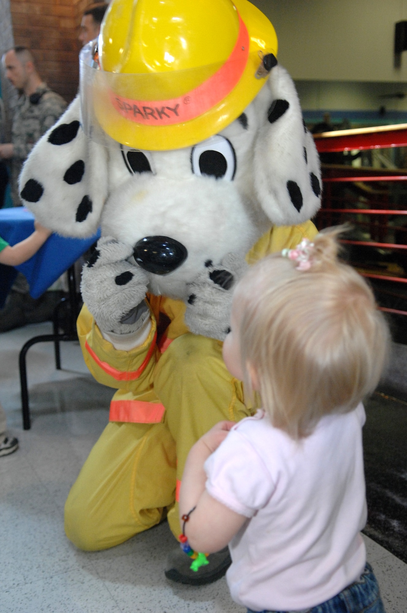WHITEMAN AIR FORCE BASE, Mo. --Sparky the firedog greets a child at Family Fitness Day April 2, 2011. The event is held annually to teach parents and children that fitness can be fun and done together. (U.S. Air Force photo by Airman 1st Class Cody H. Ramirez)