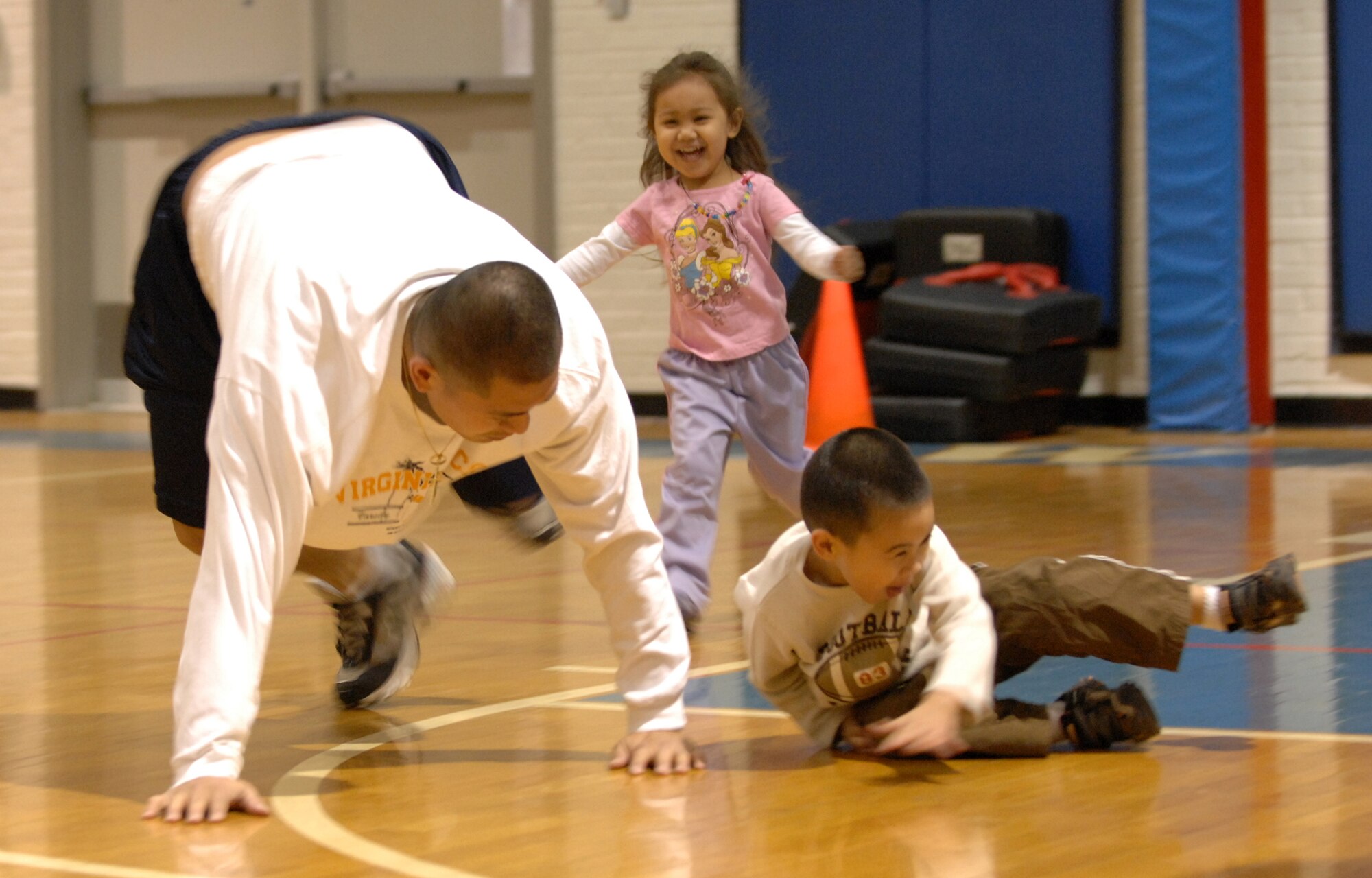 WHITEMAN AIR FORCE BASE, Mo. -- Staff Sgt. Jaime Vergara and his children, Jaden and Jazlene, bear crawl through Kidz Rush April 2, 2011. The event is held annually to teach parents and children that fitness can be fun and done together. (U.S. Air Force photo by Airman 1st Class Cody H. Ramirez)