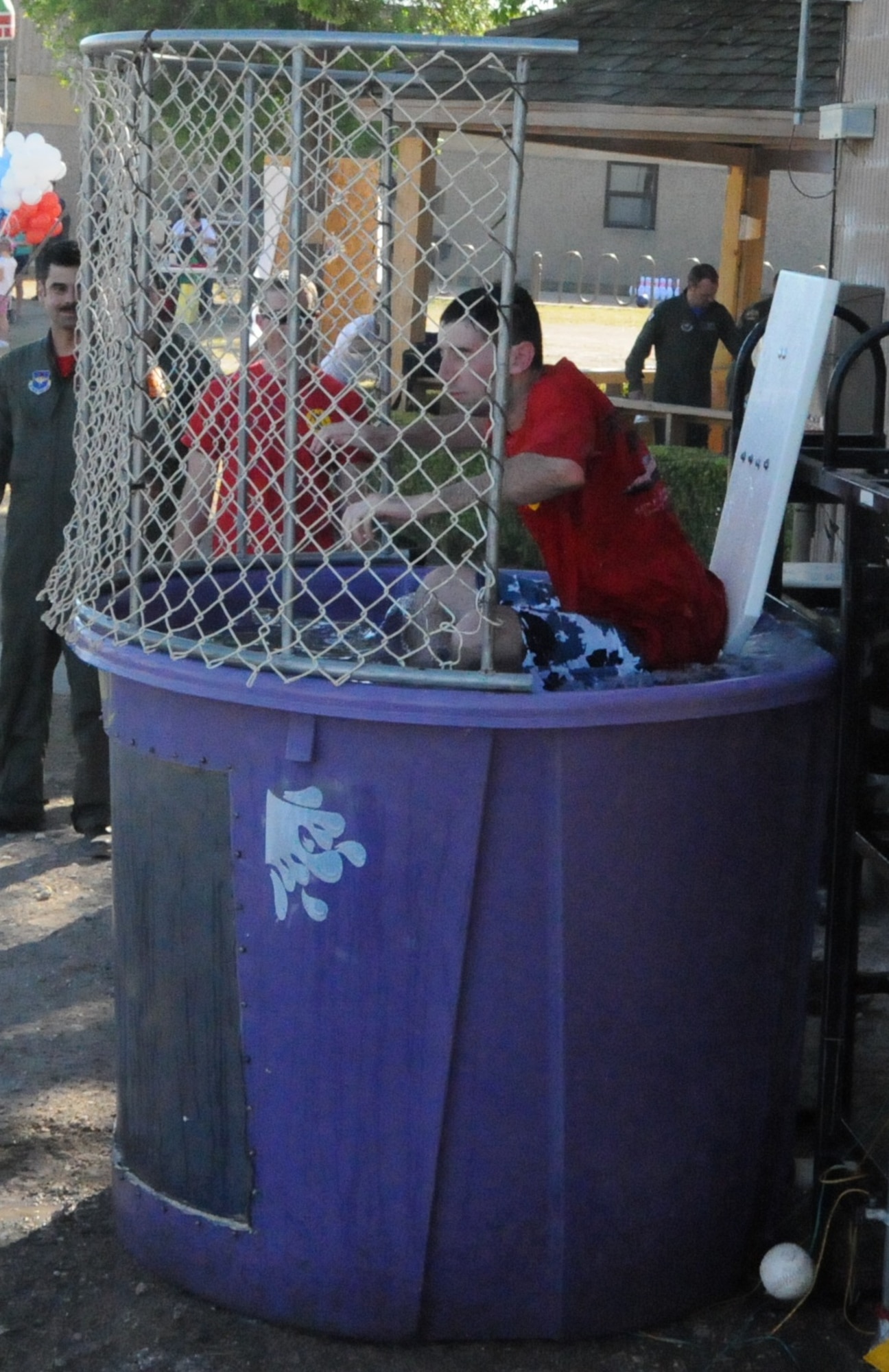 LAUGHLIN AIR FORCE BASE, Texas – First Lt. Dan Cascio, 84th Flying Training Squadron, splashes into the water of a dunk tank at the T-6 Carnival near Laughlin’s flight line April 1. The Carnival also included horseback riding, a bouncy castle, carnival games, a burger burn and an ice cream-eating contest. (U.S. Air Force photo by Airman 1st Class Blake Mize)    
