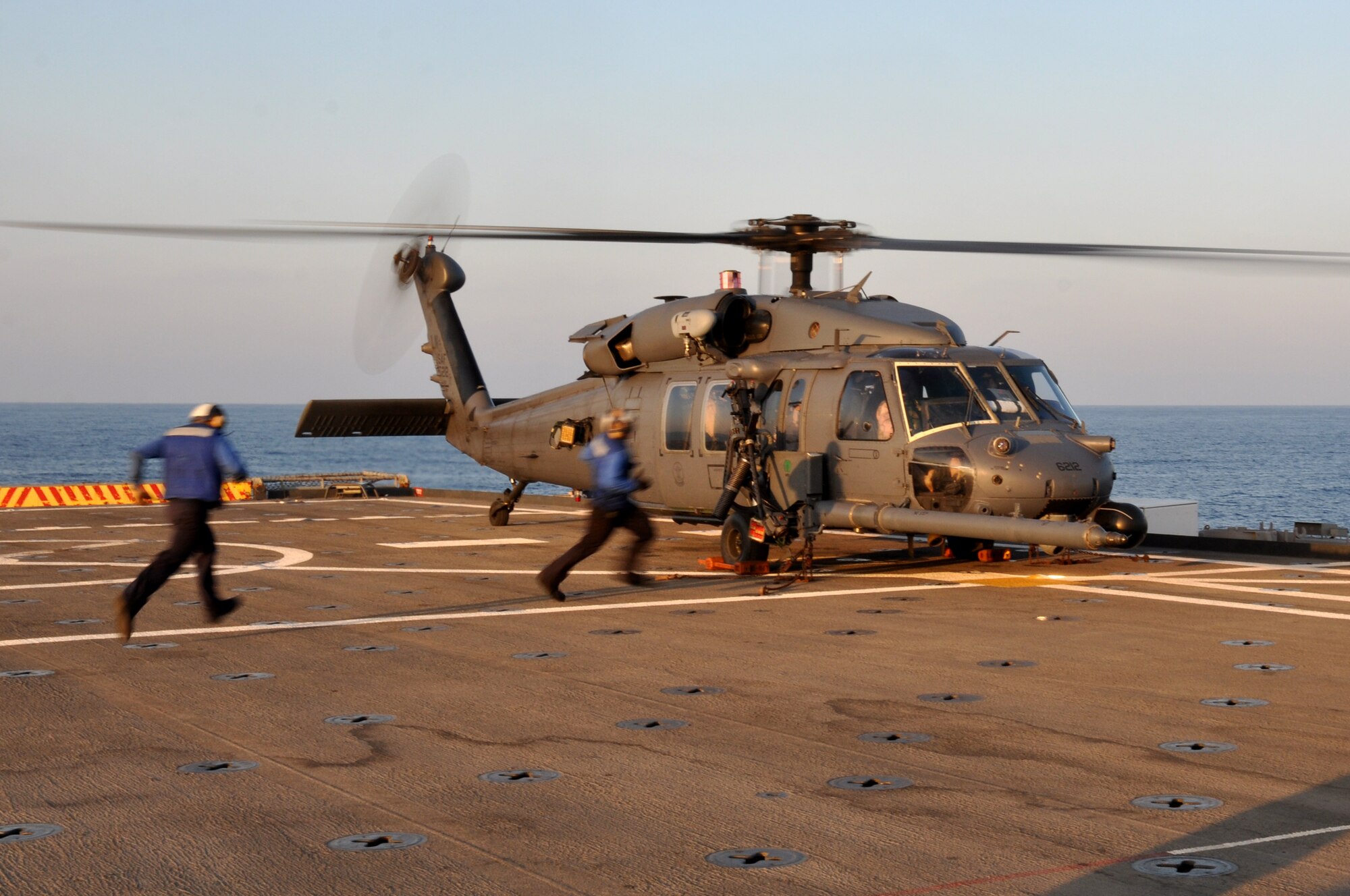 MEDITERRANEAN SEA - Aviation Support Equipment Technician Airman Riley Tanner (left) and Aviation Boatswain’s Mate (Handler) Airman David Singh run to remove the chocks and chains securing a U.S. Air Force HH-60G Pave Hawk from the 56th Rescue Squadron so it can take off from amphibious transport dock USS Ponce (LPD 15) during evening training operations on March 25, 2011. Elements of the 56th Rescue Squadron, which is based out of RAF Lakenheath, England, embarked aboard Ponce to provide search and rescue coverage for pilots enforcing the no-fly zone over Libya. Ponce is part of Kearsarge Amphibious Ready Group, supporting maritime security operations and theater security cooperation efforts in the U.S. 6th Fleet area of responsibility. (U.S. Navy photo by Mass Communication Specialist 1st Class Nathanael Miller)