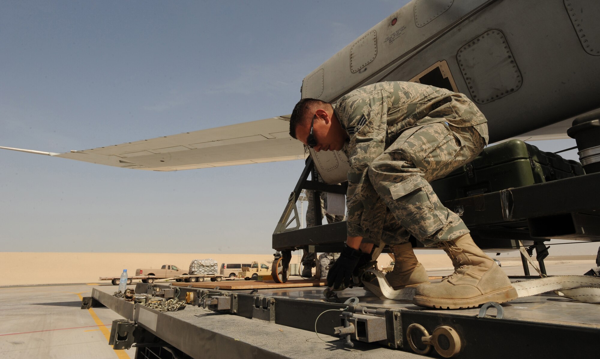 Senior Airman Adrian Gonzales, 380th Expeditionary Logistics Readiness Squadron, unhooks equipment before signaling the forklift driver to unload it from the 60k Tunner Loader Mar. 10, 2011, in Southwest Asia. The 380th ELRS members assisted their host nation counterparts for the first time in the Air Terminal Operation Center's history with unloading F-16 Desert Falcon equipment used during this year's Red Flag. Airman Gonzales is deployed from the 89th Aerial Port Squadron, Andrews AFB, Md. (U.S. Air Force photo by Senior Airman Maynelinne De La Cruz)