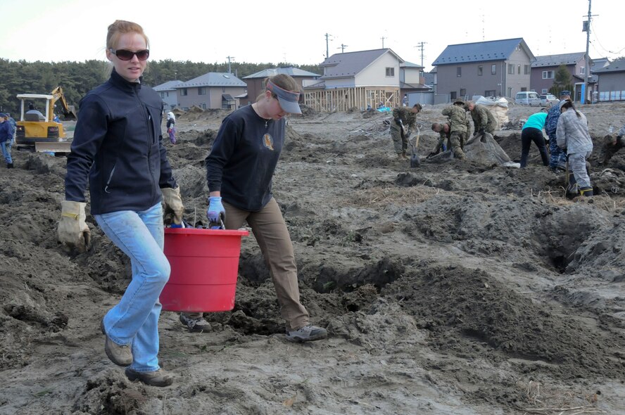 HACHINOHE, Japan -- Civilian volunteers from Misawa Air Base carry debris off a strawberry field, here April 1. To date, more than 1,200 servicemembers and civilian volunteers from Misawa Air Base have spent more than 9,000 man-hours assisting local communities with recovery efforts. (U.S. Air Force photo by Staff Sgt. Rachel Martinez/Released)