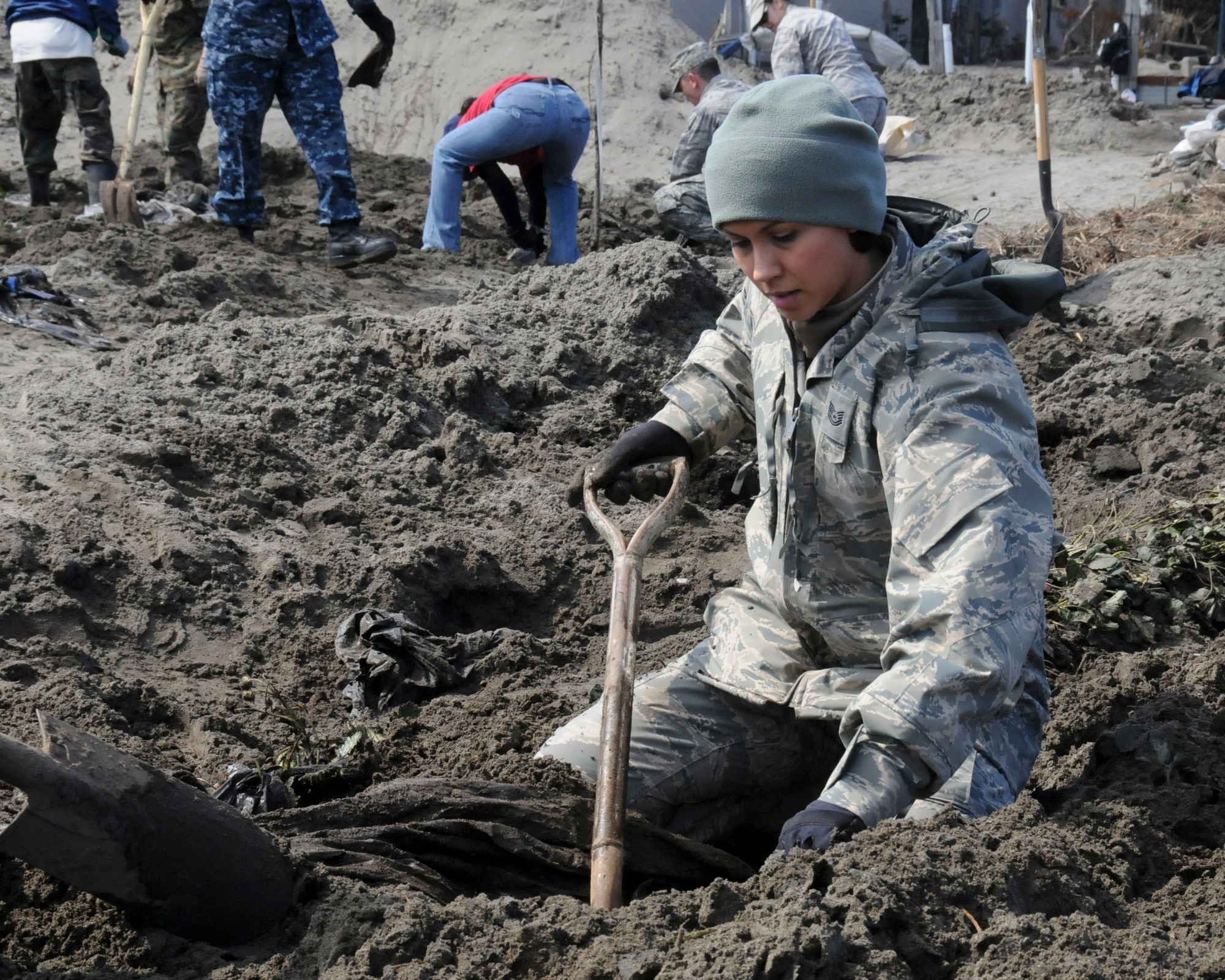 HACHINOHE, Japan -- A U.S. Air Force Airman from Misawa Air Base digs through a strawberry field looking for debris, here April 1. Approximately two busloads of volunteers visited the Hachinohe strawberry fields every day during the week to assist local farmers with cleaning up the destruction left by a tsunami. (U.S. Air Force photo by Staff Sgt. Rachel Martinez/Released)