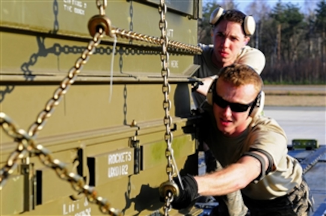 U.S. Air Force Airman 1st Class Bradley Stinson and Airman 1st Class Casey Williams, with the 721st Aerial Port Squadron, load cargo onto a C-130J Super Hercules aircraft at Ramstein Air Base, Germany, in preparation for its departure in support of Operation Odyssey Dawn on March 23, 2011.  