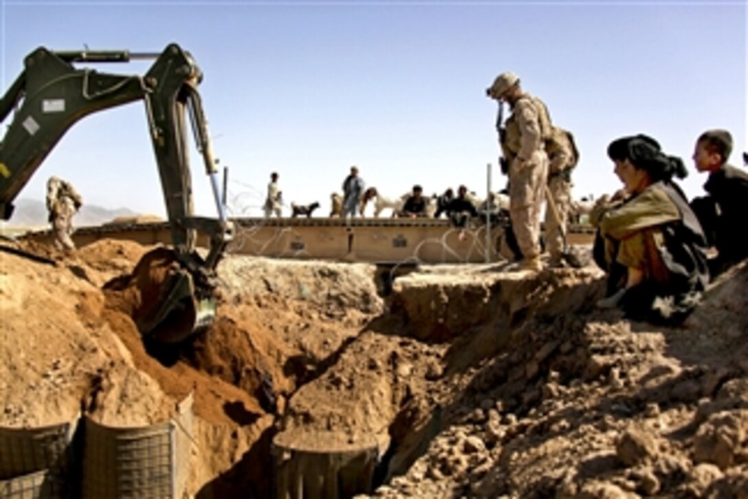 U.S. Marine Corps 1st Lt. Daniel Hough and Afghans watch as Marines remove a bridge and culvert at Kakar village, Helmand province, Afghanistan, on March 28, 2011. Hough is assigned to the 3rd Battalion Landing Team, Regimental Combat Team 8.  