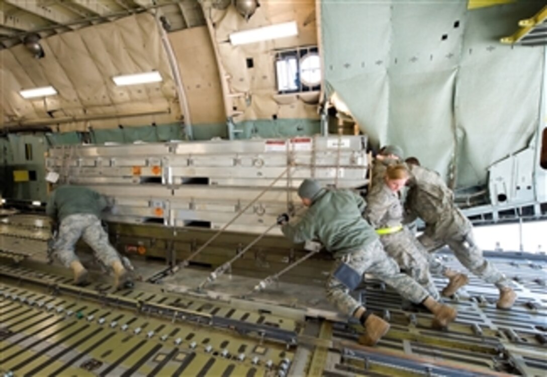Airmen load cargo onto a C-5M Super Galaxy aircraft at Dover Air Force Base, Del., on March 25, 2011.  The cargo is bound for Italy in support of Operation Odyssey Dawn.  