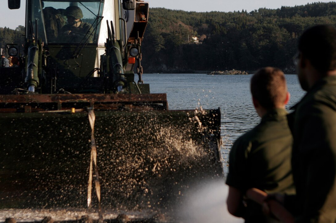 Sailors from the USS Essex (LHD 2), spray down heavy equipment before loading it onto a U.S. Navy landing craft utility, April 6. The Marines and Sailors spent about six days cleaning up debris on parts of the island, during Operation Field Day. The 31st MEU’s involvement is part of the larger Operation Tomodachi, coordinated after a 9.0 earthquake and subsequent tsunami struck Japan causing widespread damage. The 31st MEU remains ready to support its Japanese partners and to provide assistance when called upon.
