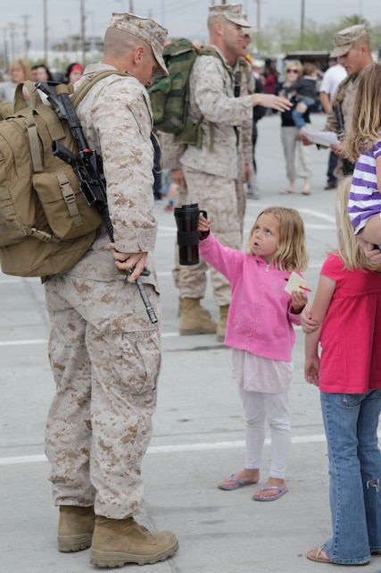 Cianna Pruitt, four-year-old daughter of Gunnery Sgt. Chris Pruitt, a platoon sergeant with Company L, 3rd Battalion, 4th Marine Regiment, hands her daddy his coffee mug shortly before his company deploys for their seven-month deployment in support of Operation Enduring Freedom.::r::::n::