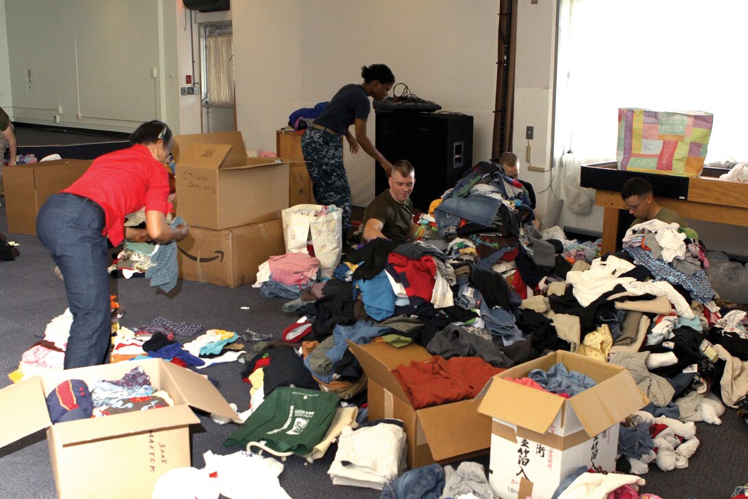 Volunteers sort and box up clothing at the USO on Marine Corps Air Station Futenma April 6 for shipment to mainland Japan to aid in the relief efforts.