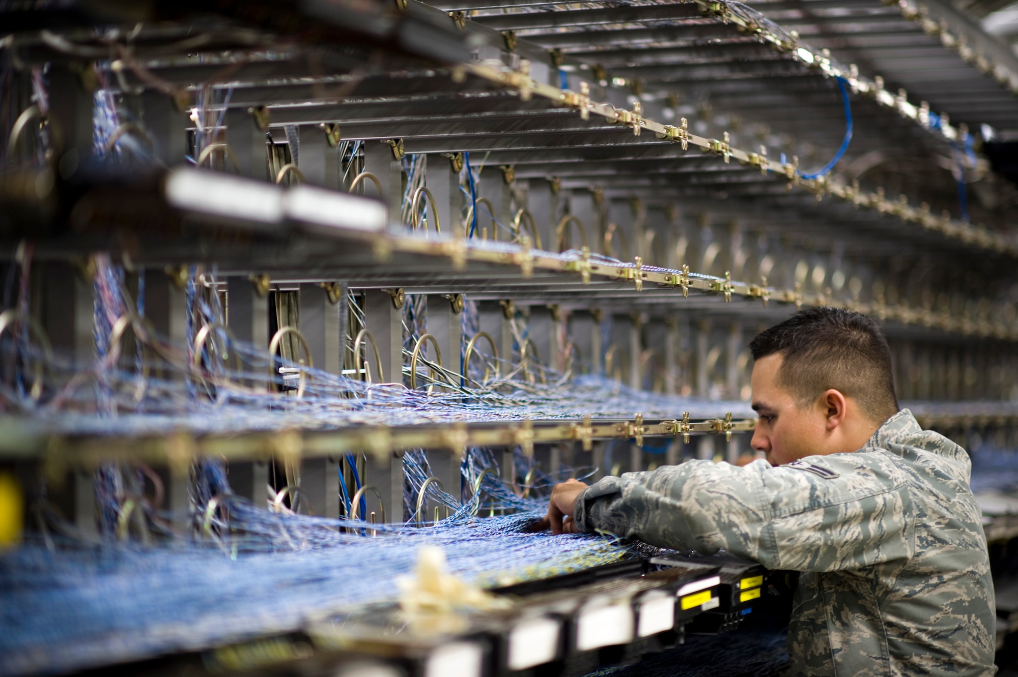 YOKOTA AIR BASE, Japan -- Airman 1st Class Nicholas Leon, 374th Communications Squadron cyber transport technician, connects a new Defense Switched Network line at the 374th CS building, Yokota Air Base, Japan, April 2, 2011. Airman Leon helped install additional DSN lines for easy communication with units temporarily assigned to Yokota AB for Operation Tomodachi. (U.S. Air Force photo/Staff Sgt. Samuel Morse)