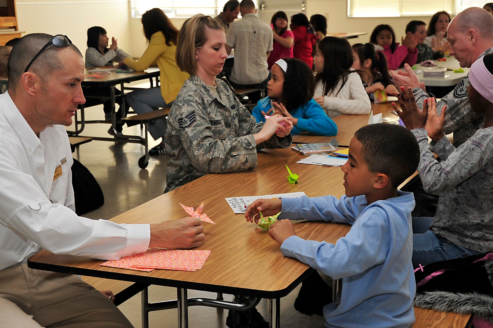 MISAWA AIR BASE, Japan -- Students along with their parents and other volunteers work together to make origami cranes at Sollars Elementary School April 6. The school has collected over 7,000 cranes and continues to work toward the goal of 100,000. The cranes will be sent to Students Rebuild to help raise funds in support of their Japanese peers. Students Rebuild is a global organization that mobilizes young people to connect, learn and take action on critical global issues. (U.S. Air Force photo by Staff Sgt. Marie Brown\Released)