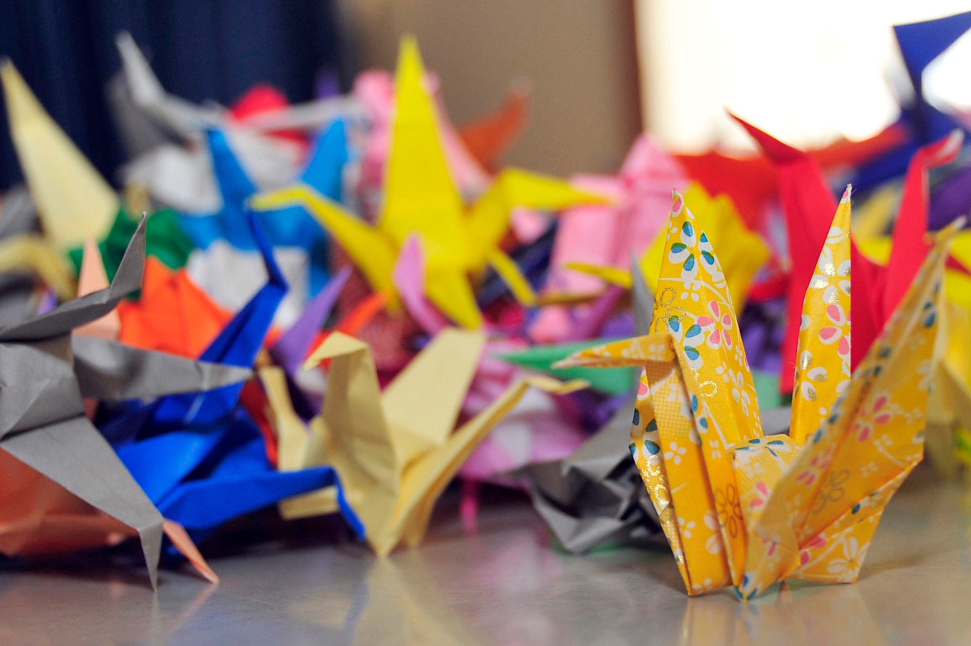 MISAWA AIR BASE, Japan -- A pile of origami cranes are displayed on a table at Sollars Elementary School April 6. Cranes are sacred creatures in Japanese culture. According to legend, anyone who folds a thousand paper cranes will be granted a wish by a crane. The cranes will be sent to Students Rebuild to help raise funds in support of their Japanese peers. Students Rebuild is a global organization that mobilizes young people to connect, learn and take action on critical issues.  (U.S. Air Force photo by Staff Sgt. Marie Brown\Released)